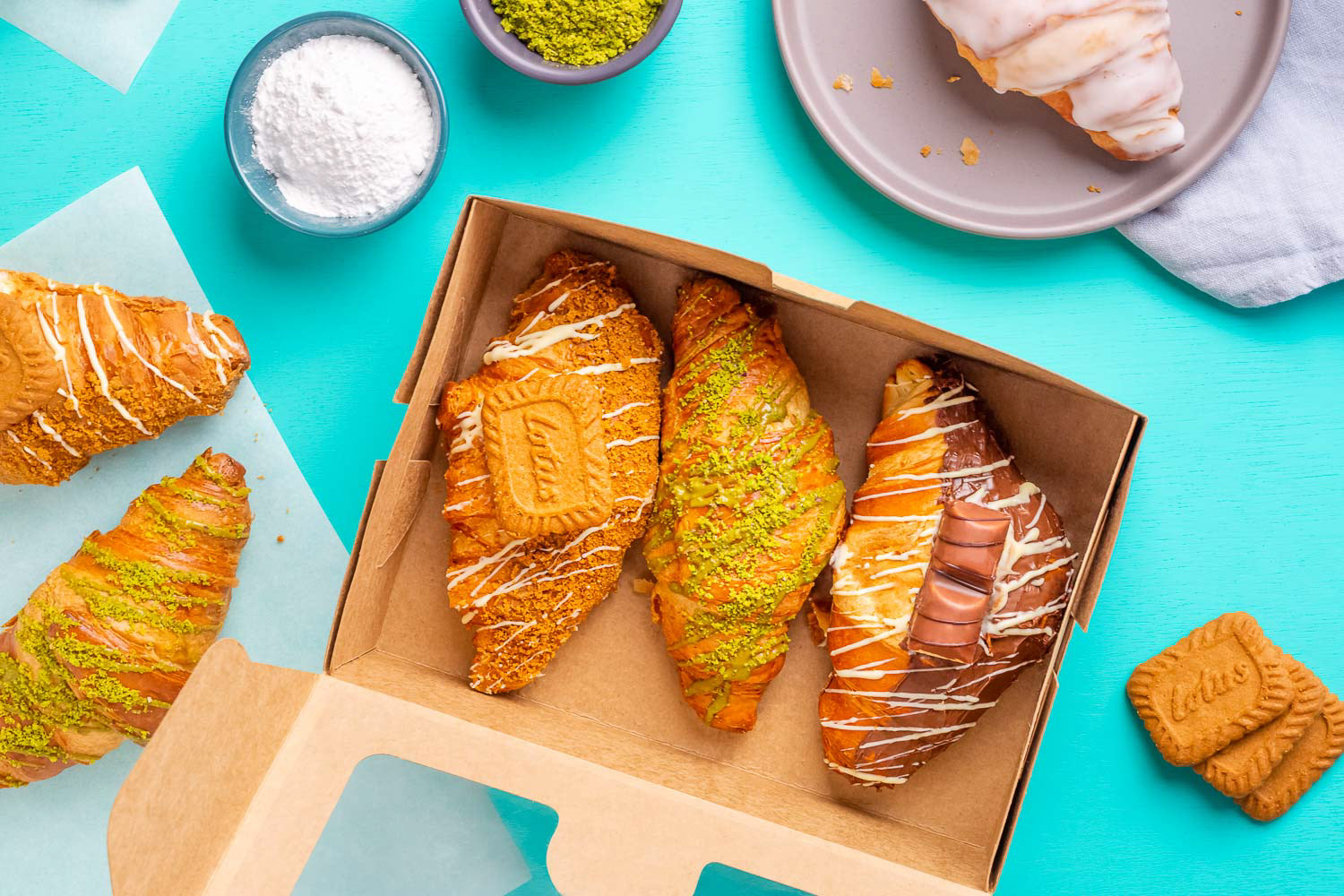 Croissants in a box on a teal background