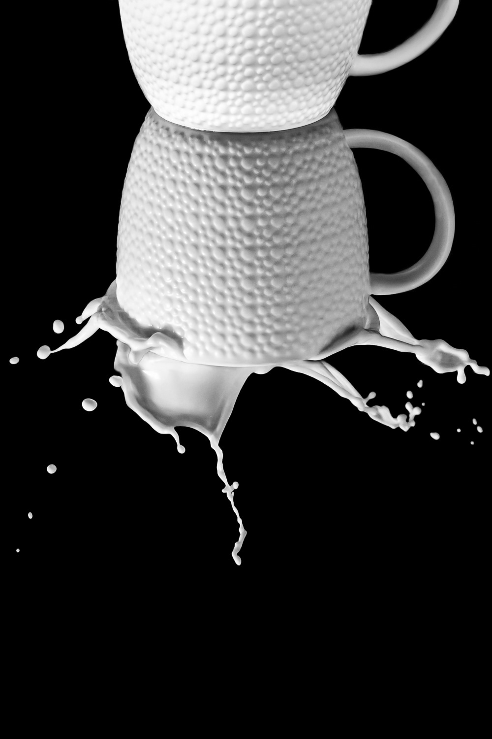 Black and white reflection of milk splashing in mug