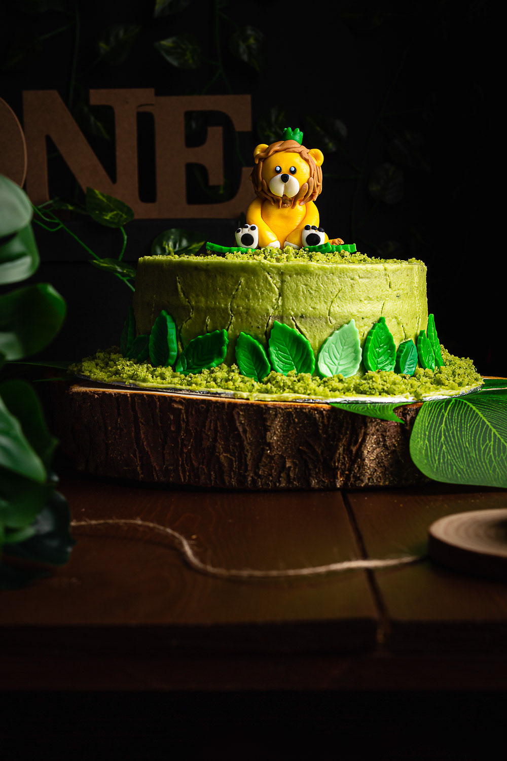 Spinach cake with lion topper on wooden tray