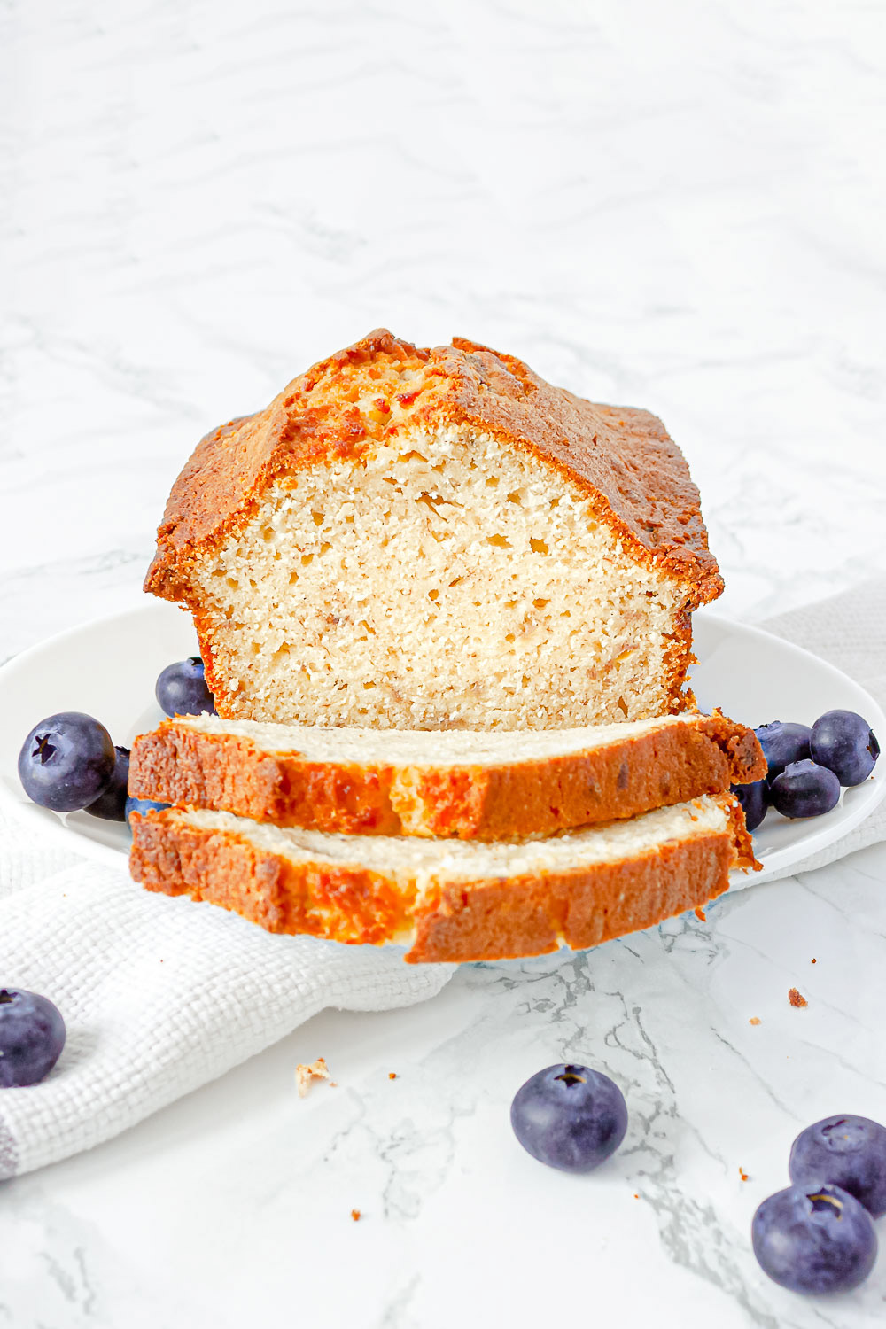 Sliced banana bread with blueberries on the side