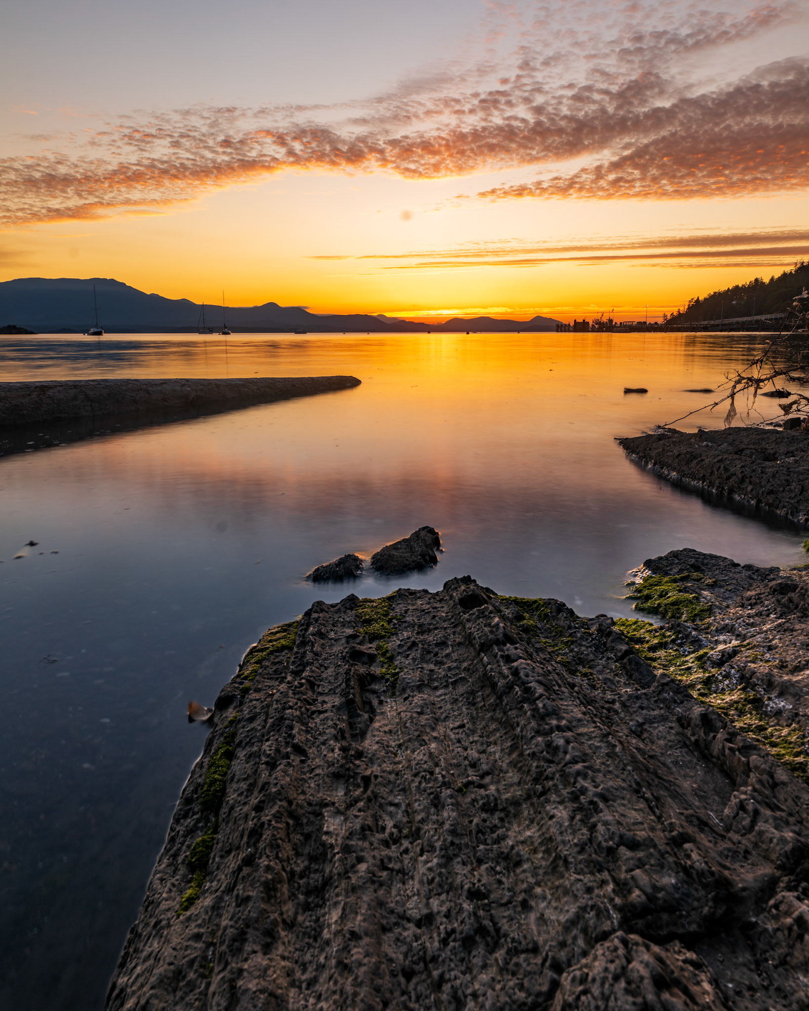 Sun setting behind the shore of Vesuvious bay, Salt Spring Island, British Columbia, Canada