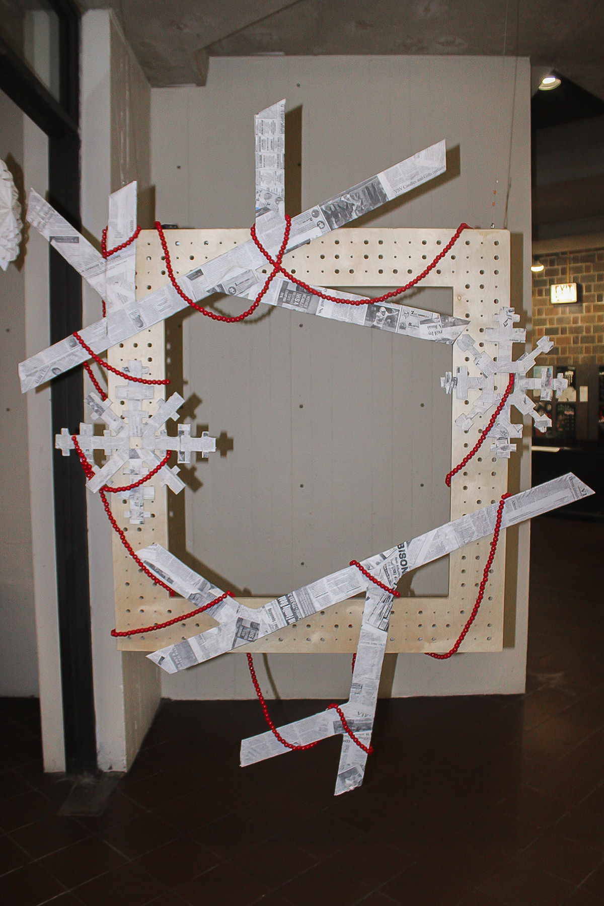 Photo frame with paper-mâché branches, snowflakes, and beads.