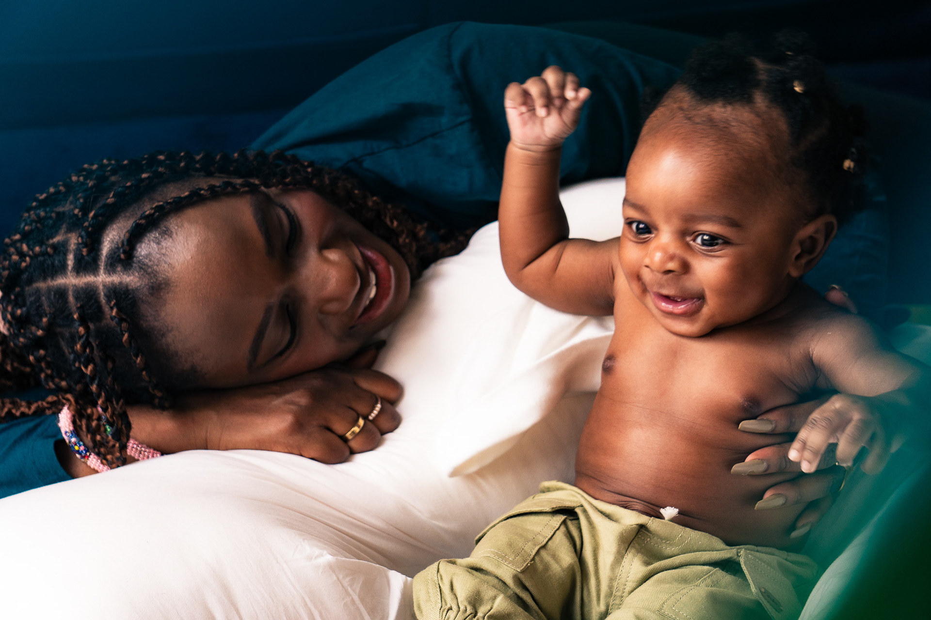 Professional intimate interior portrait of a mother and her child playing, in warm tones and natural light, in Nairobi Kenya