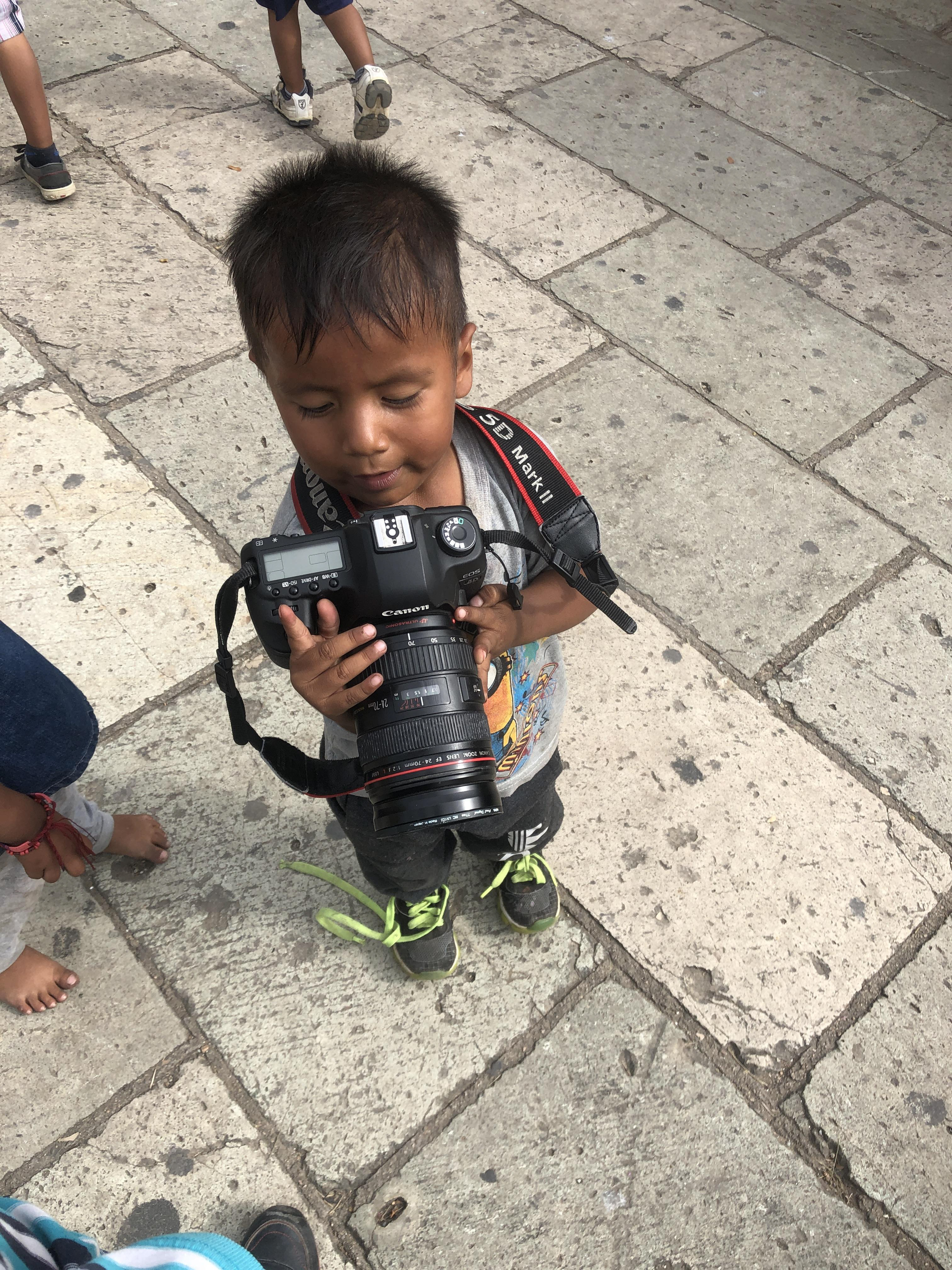 Kico with Juan Escobedo's camera is in intrigued by the images and camera. 