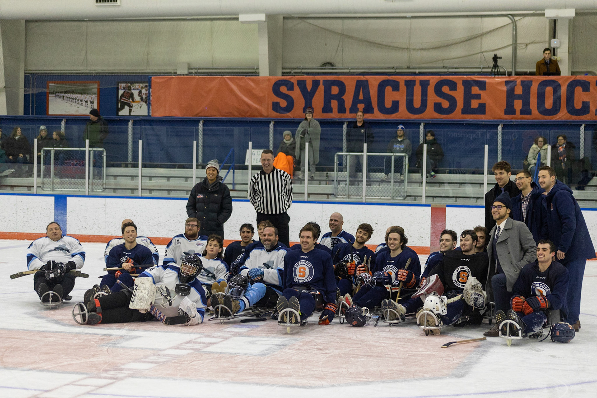 The CNY Flyers, a sled hockey team, played against the Syracuse University Men's Club Hockey team on 11/19/22 at Tennity Ice Skating Pavilion. The game ended with the Flyers scoring 8 to Syracuse 0 with 25 shots on goal by the Flyers compared to Syracuse's 2. While the game was still competitive, it was more for the fun of the sport with smiles shared by all. It was also a new experience for the Syracuse team which consisted of able-bodied individuals who may have never experienced sled hockey. At the end the teams line up for a picture. Thank you to Kelly Johnson and Aaron Landers from the Tennity Recreational Sports team for making this game possible!