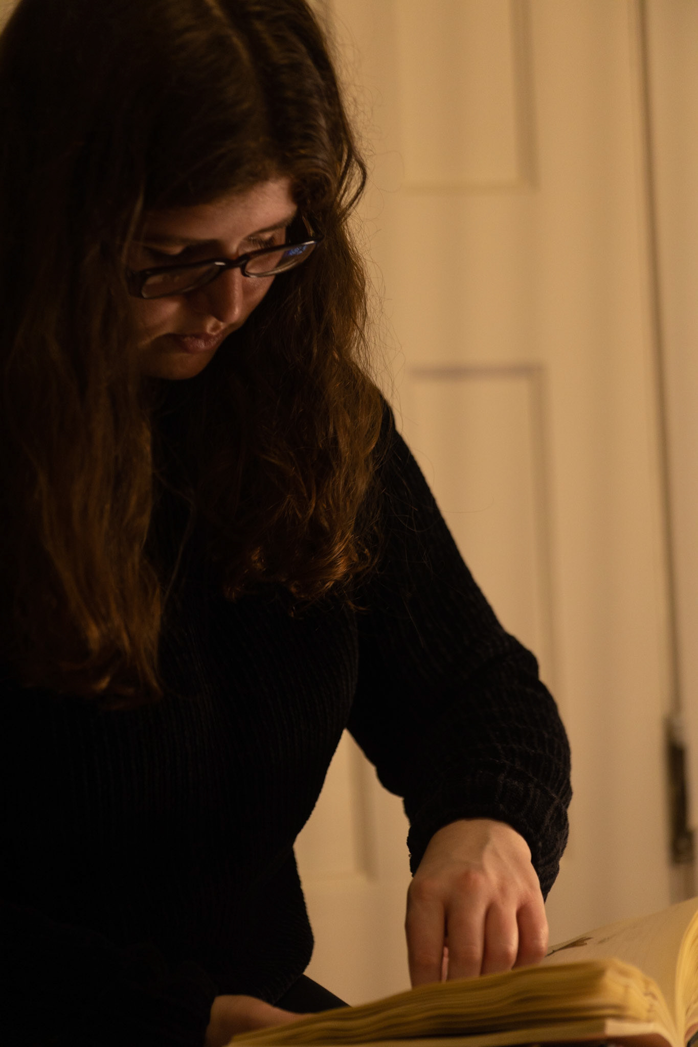 Emily Steinberger captures photos that simulate the layout of a page for her final Honor Thesis Project. The project is focused on conserving Steinberger's family history which was heavily affected by the Holocaust. Taken at Emily's apartment on 04/02/2022. Most of the materials used by Emily had been collected before the project started, either being photos or flowers.