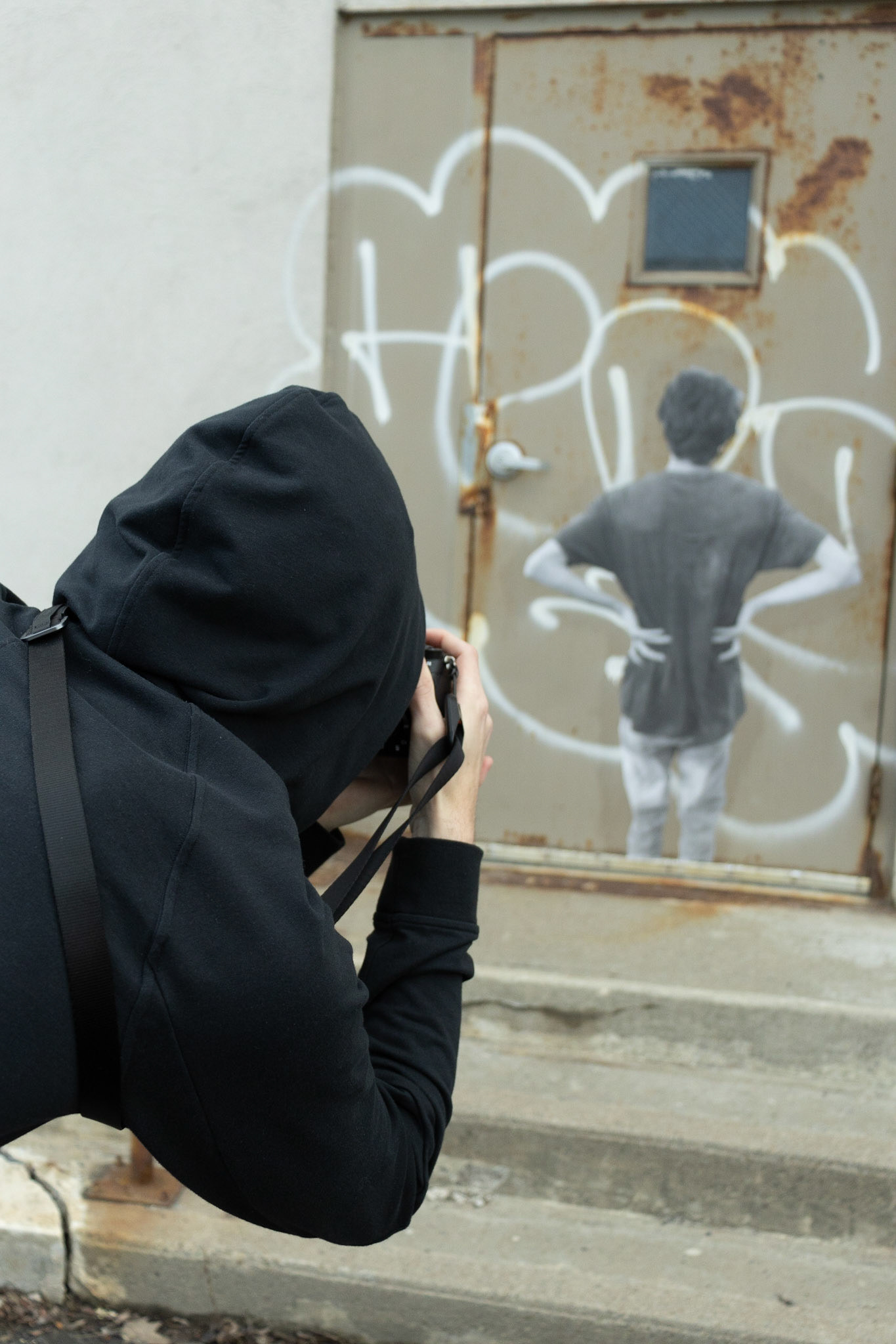 Jacob Wilkes, while taking pictures of street art he has worked on, enters and explores the Abandoned Train Station in Syracuse. Taken on 04/04/2022. On the door of an old canning facility in Syracuse, a work of Jacobs can be seen plaed upon the dorr leading inside. Returning after leaving the piece out for days on, Jacob takes a picture and then promptly moves onto the next.