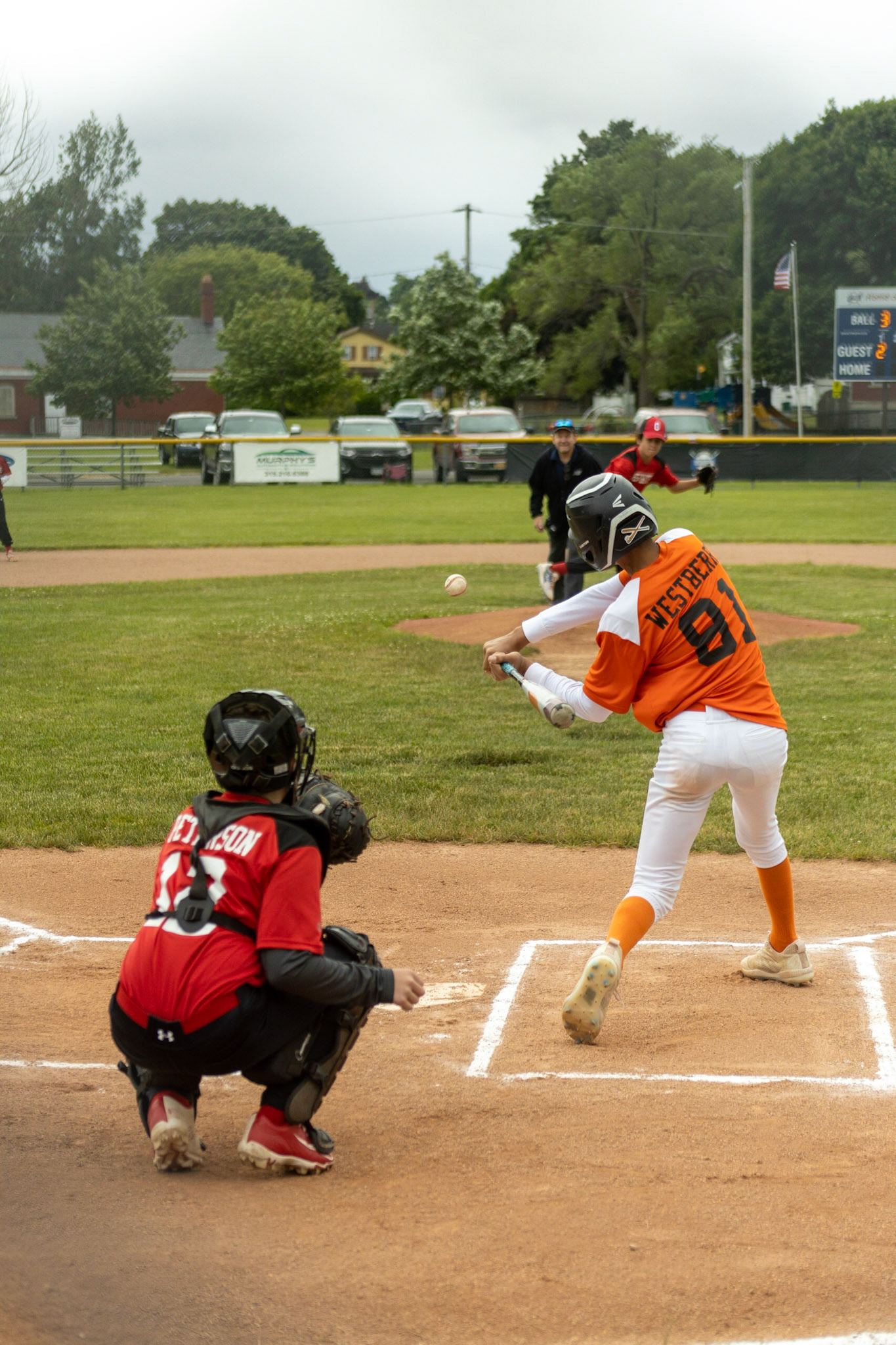 Deatyne Westberry (#81) of the Elks swings to hit a pitch from Cole Conzone (#9) during the June 18th game at Lagoe field between the Firefighters and the Elks. William Peterson (#12) would ultimately catch the pitch.