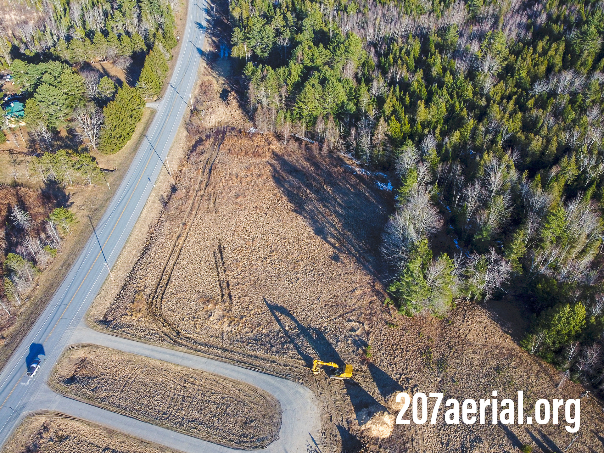 A tractor sits where there once was a farm with horses. Eddington, Maine. (April 2023)
