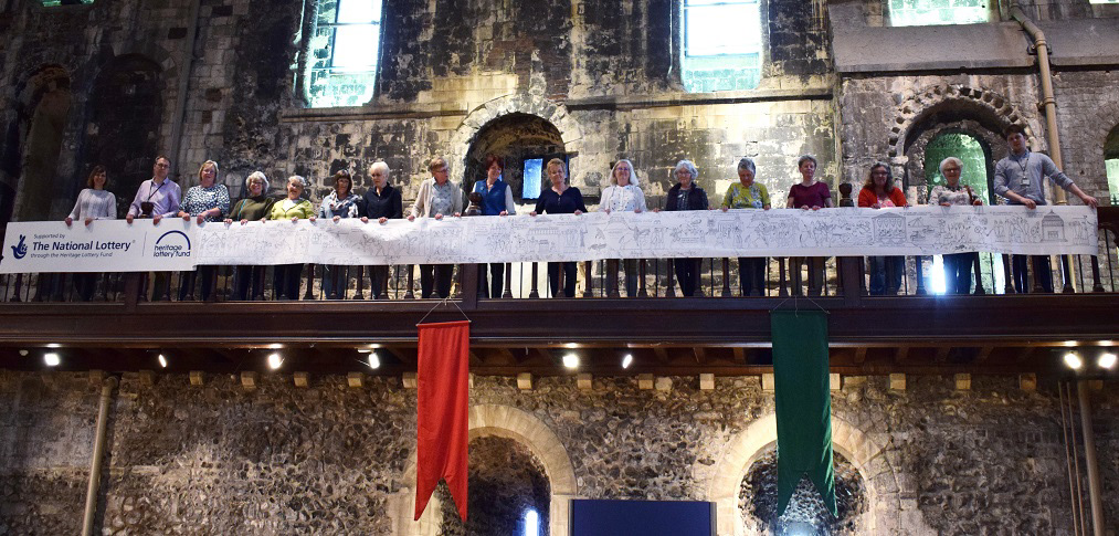 The embroidery team, with the full size tapestry design. Photo: Norfolk Museums service
