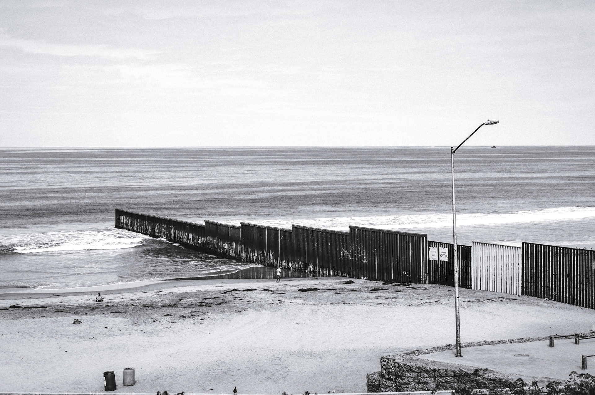 Border fence disappears into the Pacific