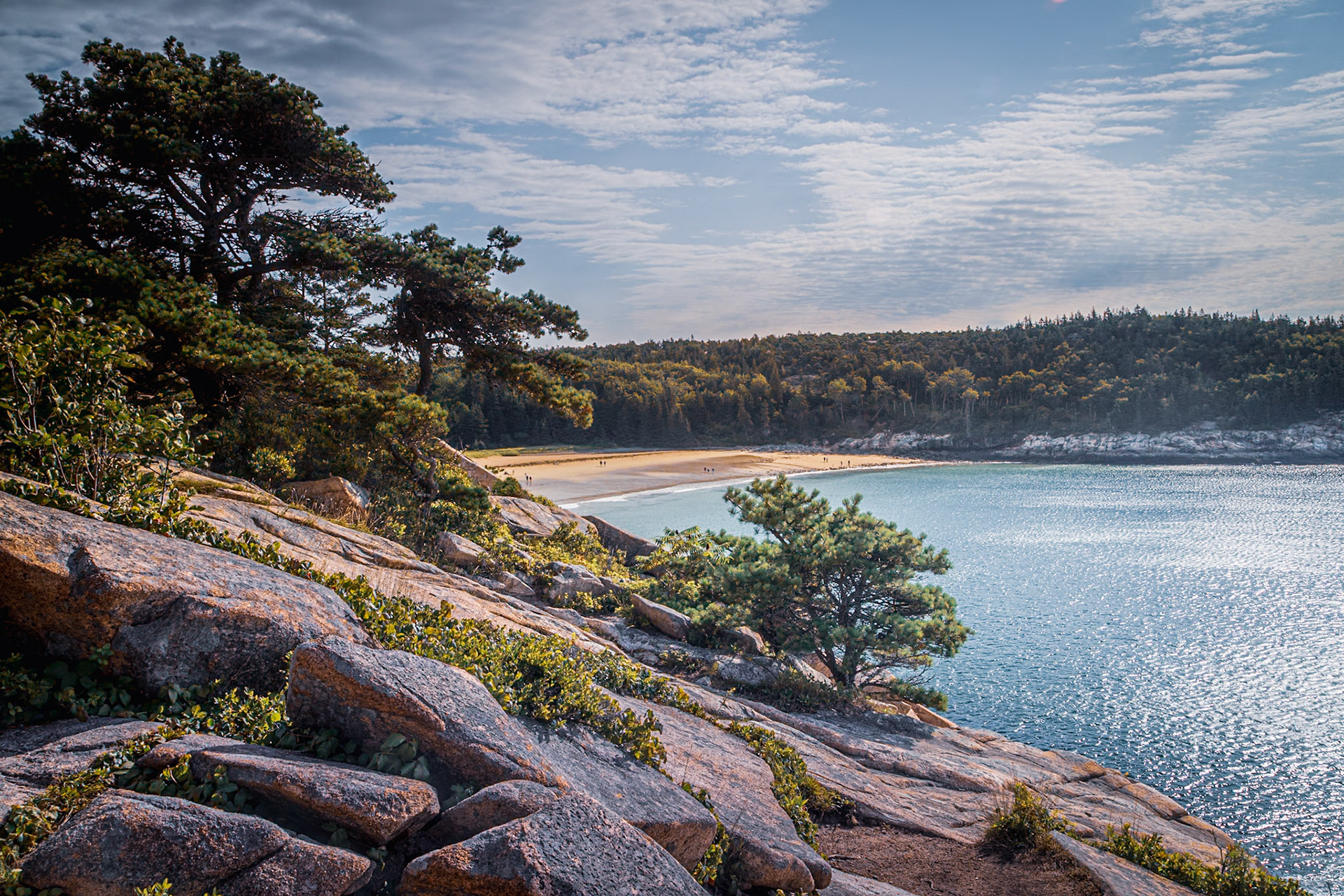 View from rocky cliff toward sandy beach in Maine