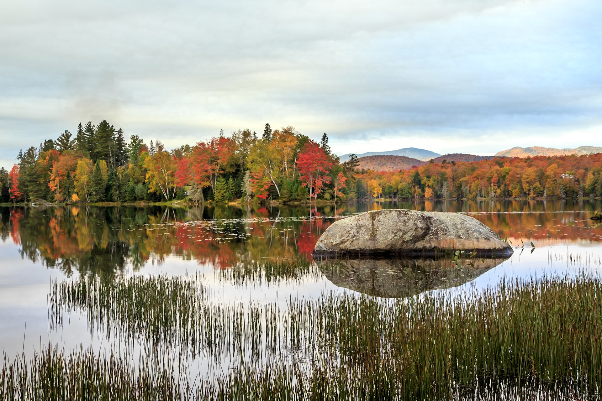 Fall colors across Lake Abanakee with mountains in the distance