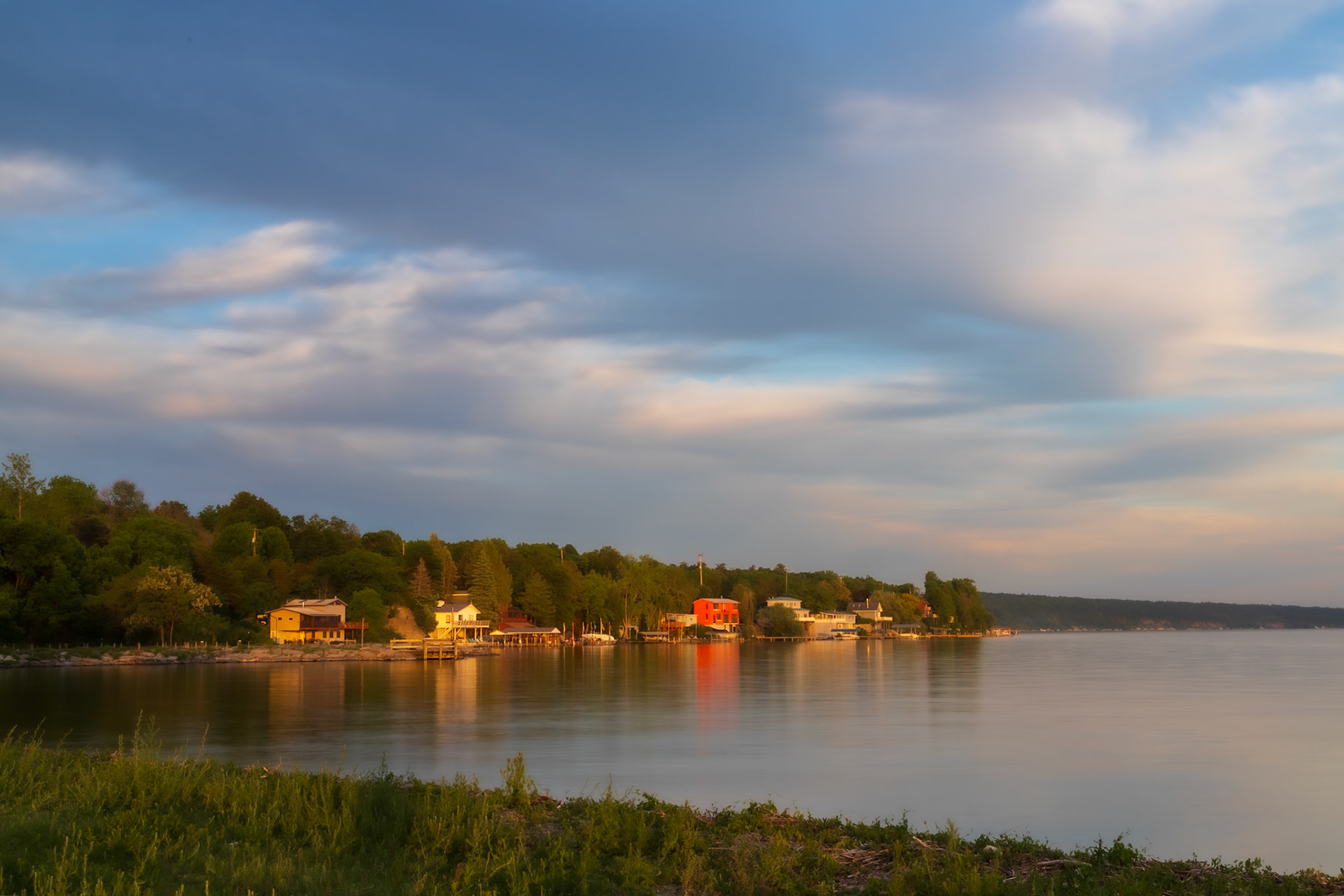 A break in the clouds lights the shoreline homes along Cayuga Lake