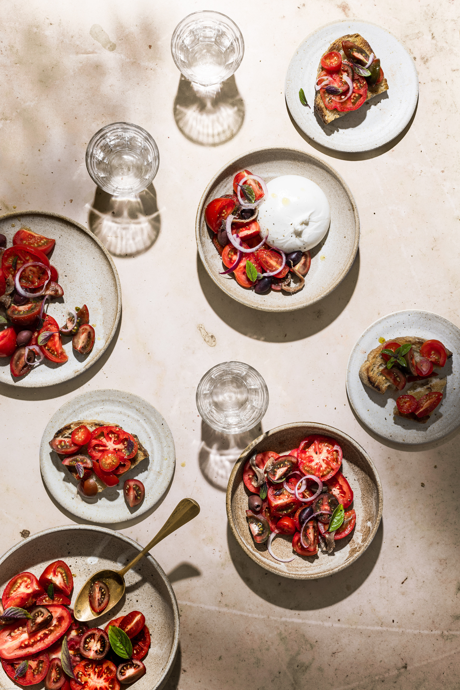 A food photography (fotografia di cibo) and food styling image of a caprese with tomatoes with hard light by Federica Melania Orsini - a food photographer (fotografo di cibo) and food stylist in Bologna.