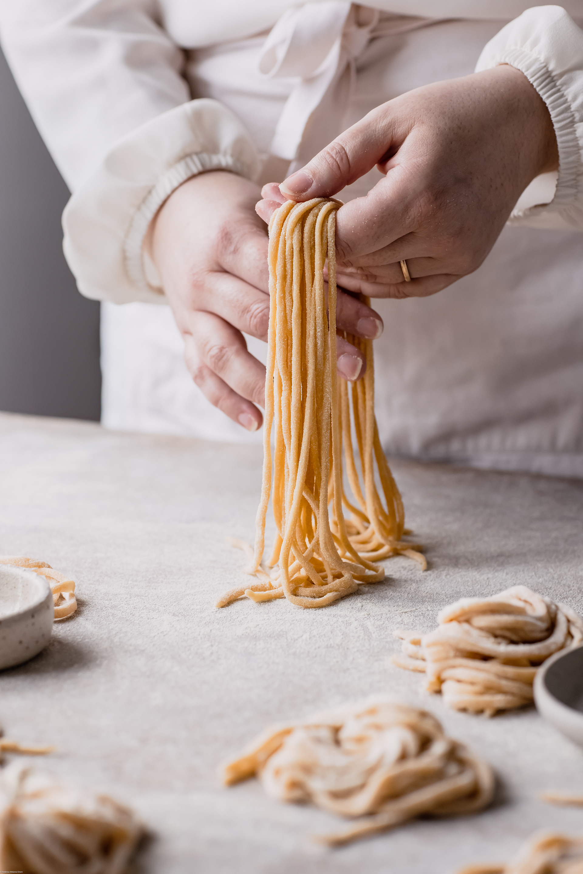 A food photography ( fotografia di cibo) image of hand holding homemade pasta by Federica Melania Orsini - a food photographer ( fotografo di cibo) in Bologna