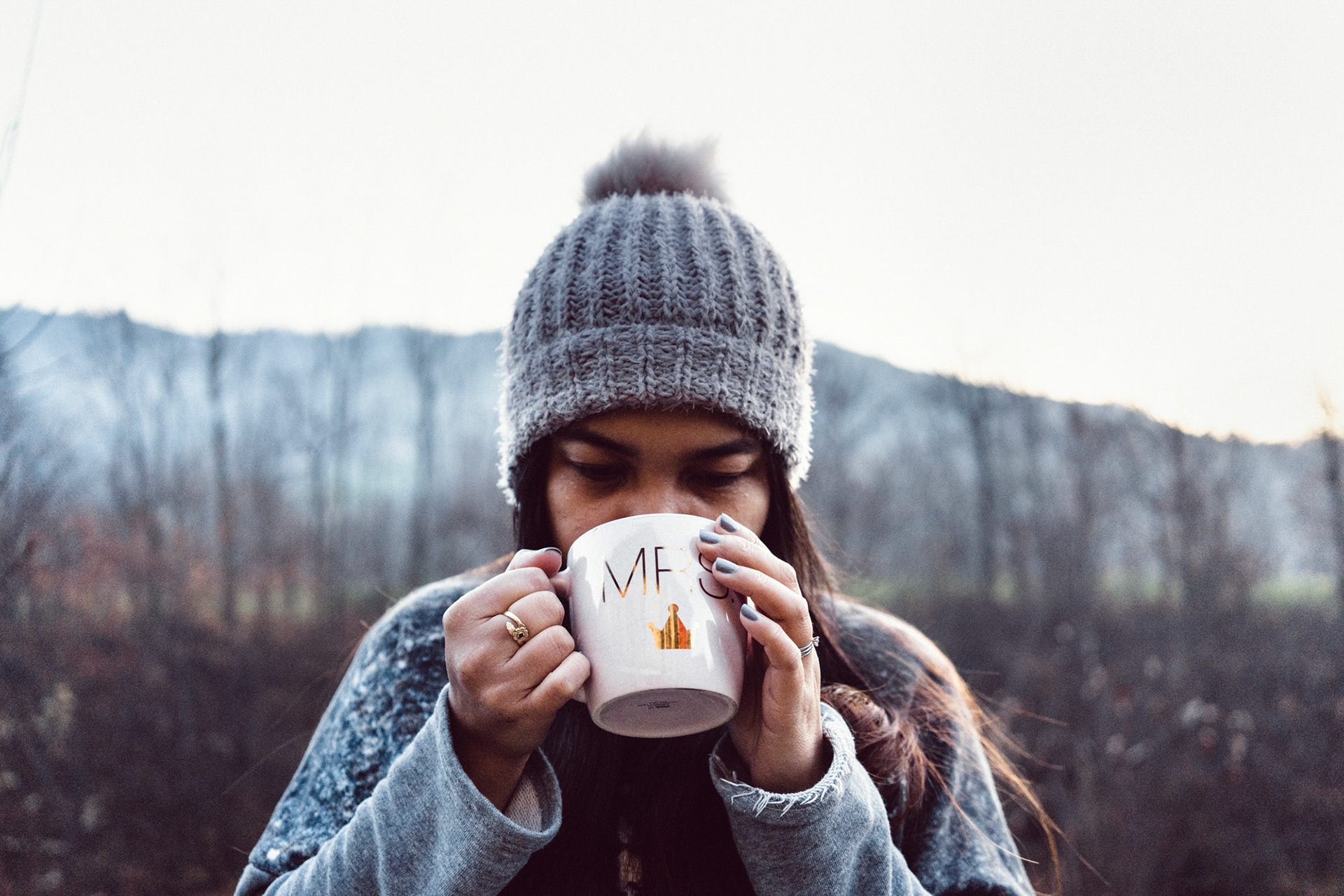 Girl sipping hot coffee outside on a cold morning in winter