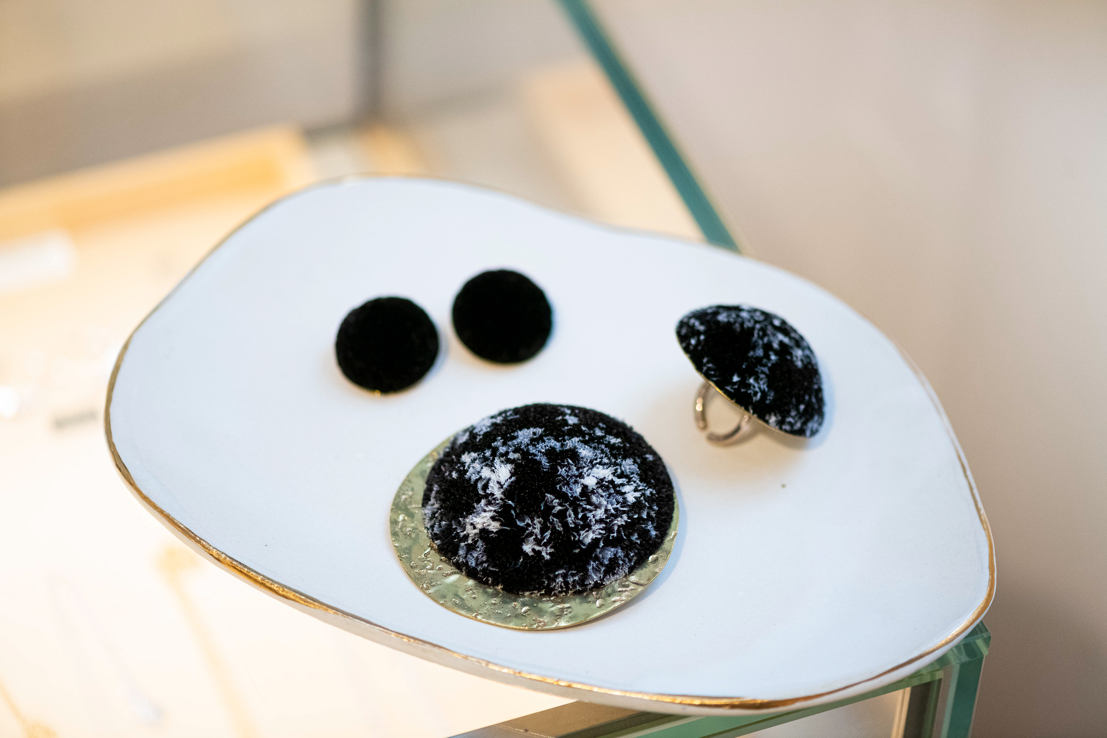 Série "NEW MOON" en exclusivité en laiton brut poli Petites boucles d'oreilles uni noir diam. 3 cm en laiton brut martelé poli et plumes d'autruche teintées noir 290€ / Grande bague diam. 5 cm 335€