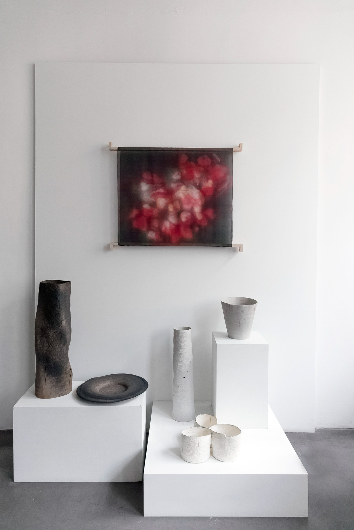Stèle noire gravée en grès 5 200€ / Plateau noir Saturne 3 800€ / Porcelaine : Stèle 1 800€ / Coupe brin d'herbes 1 500€Tryptique 2 200€ /