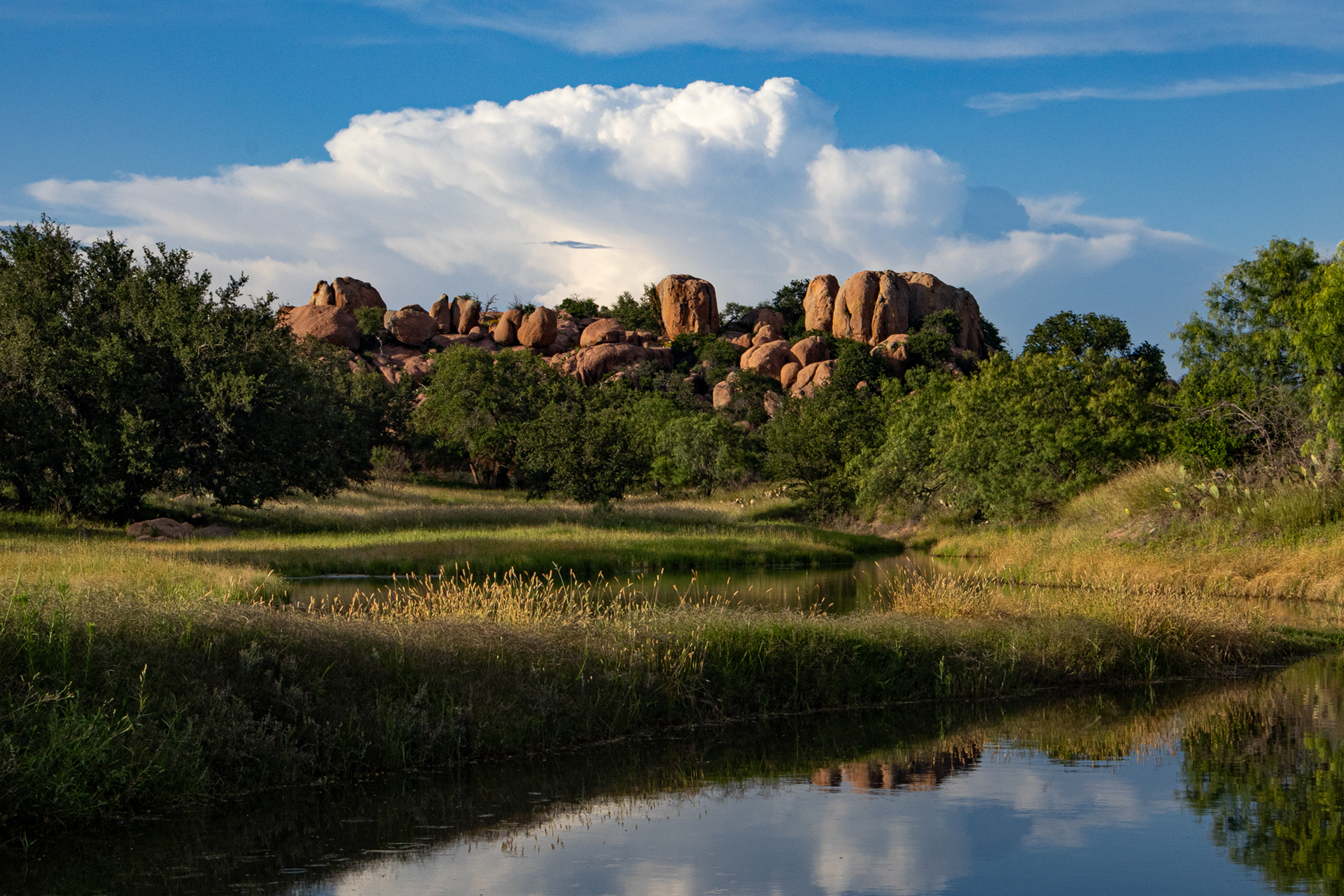 A granite outcrop overlooks an evening-lit creek at Mason Mountain Wildlife Management Area in Mason County, Texas.
