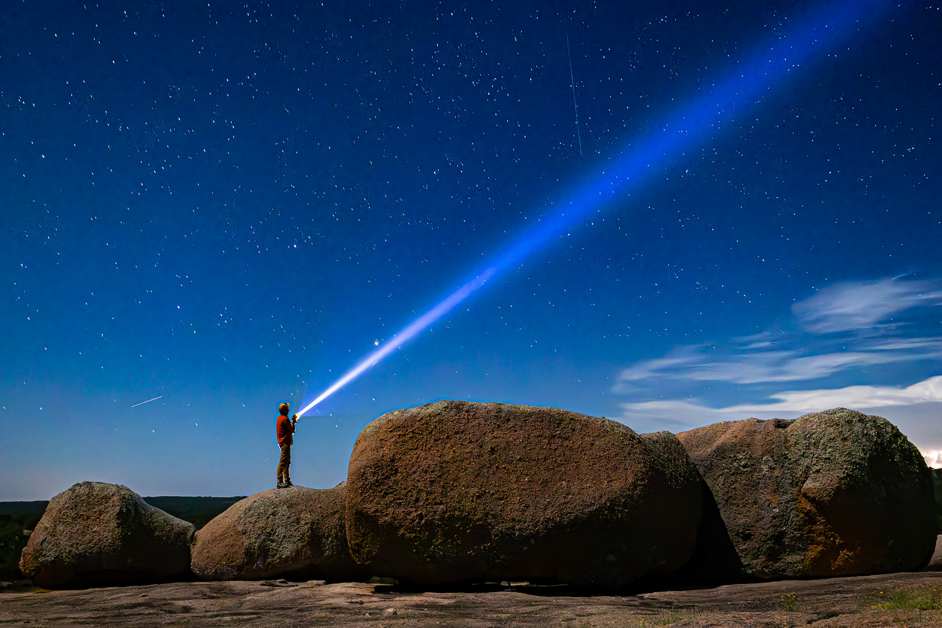 Jerod Foster, Ph.D. shines a flashlight into the night sky atop a granite outcrop at Mason Mountain Wildlife Management Area in Mason County, Texas.