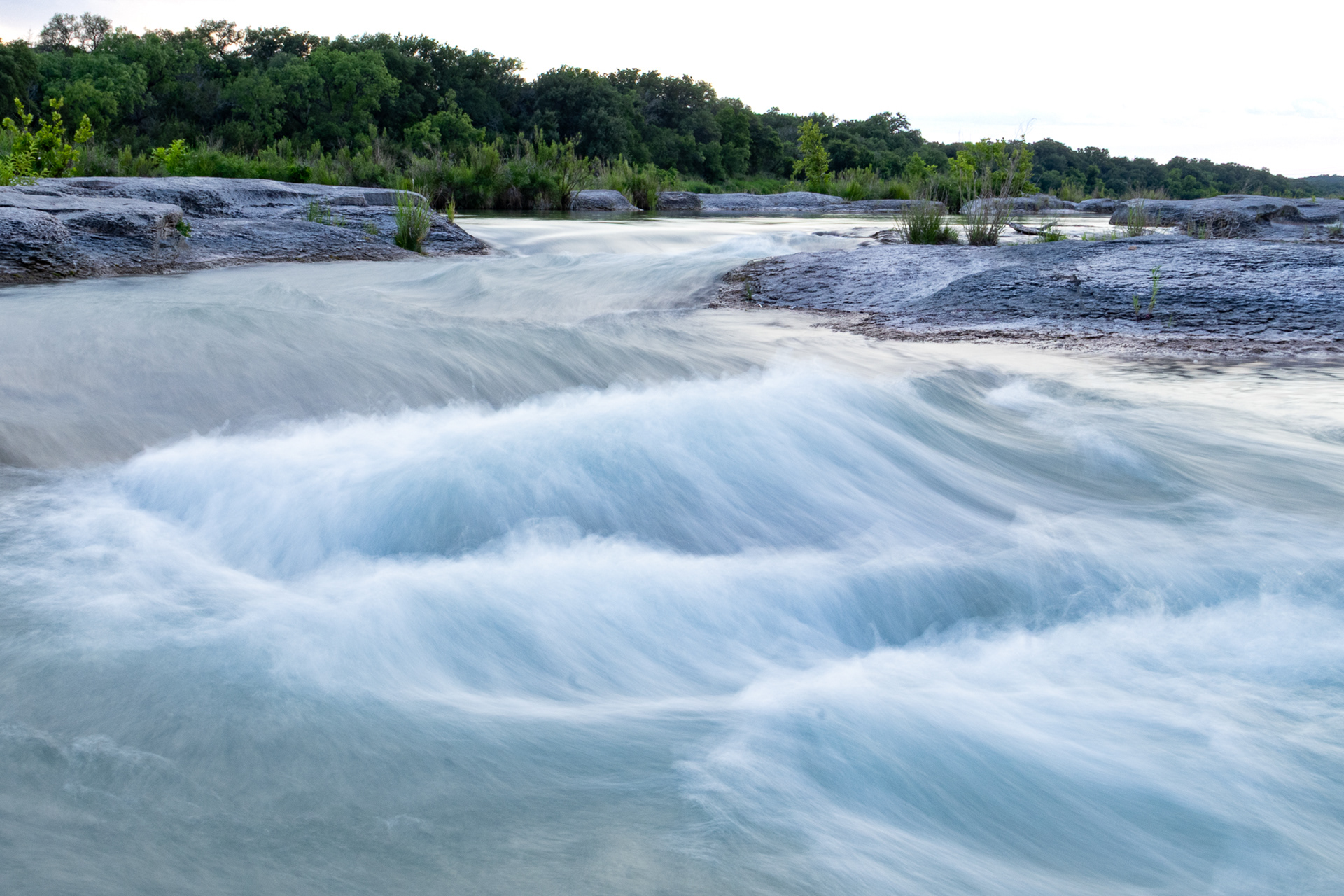 Water cascades in the evening down the Llano River in Kimble County, Texas.