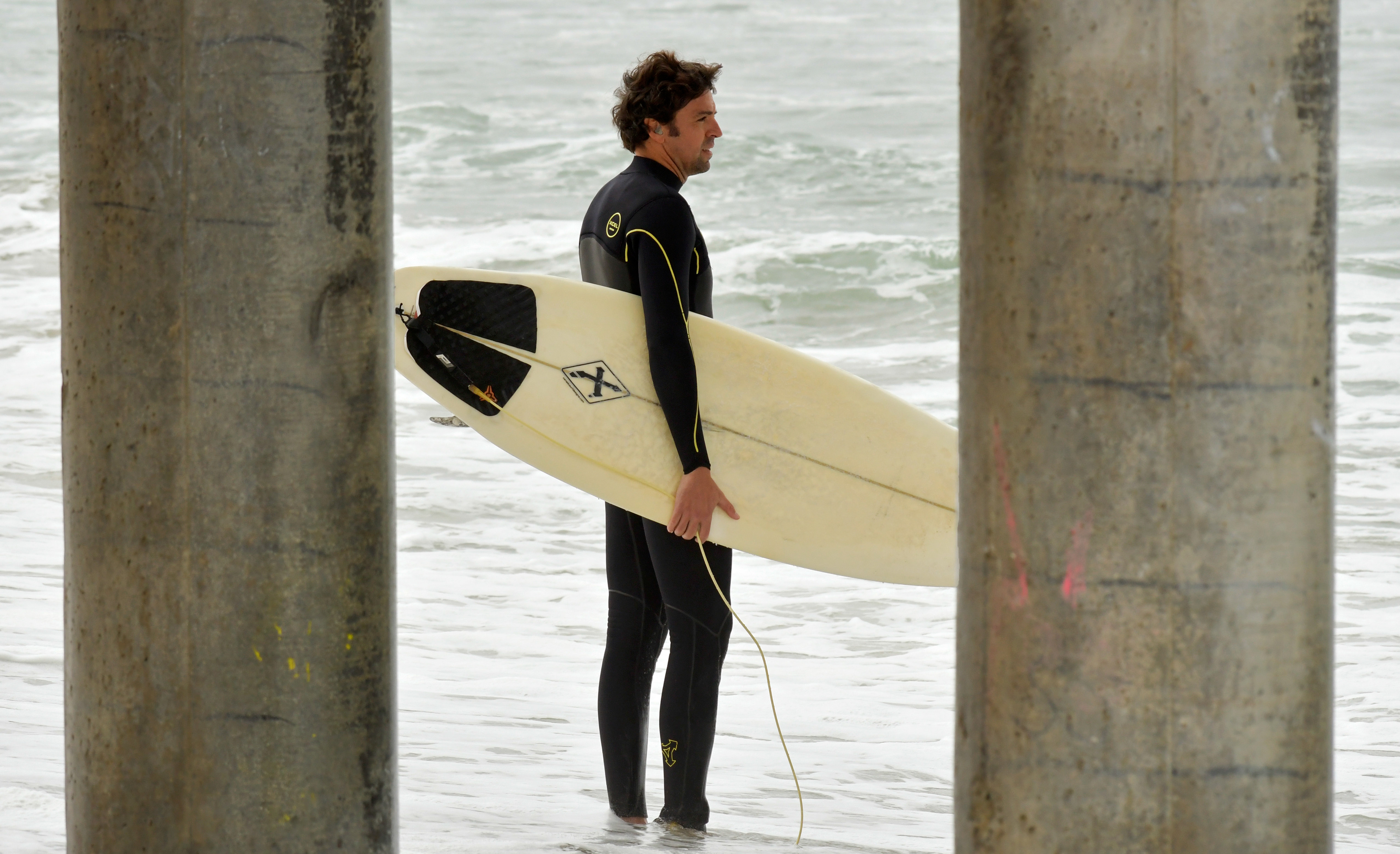 A surfer surveys the waves at Huntington Beach, Calif. on Apr. 26, 2018.