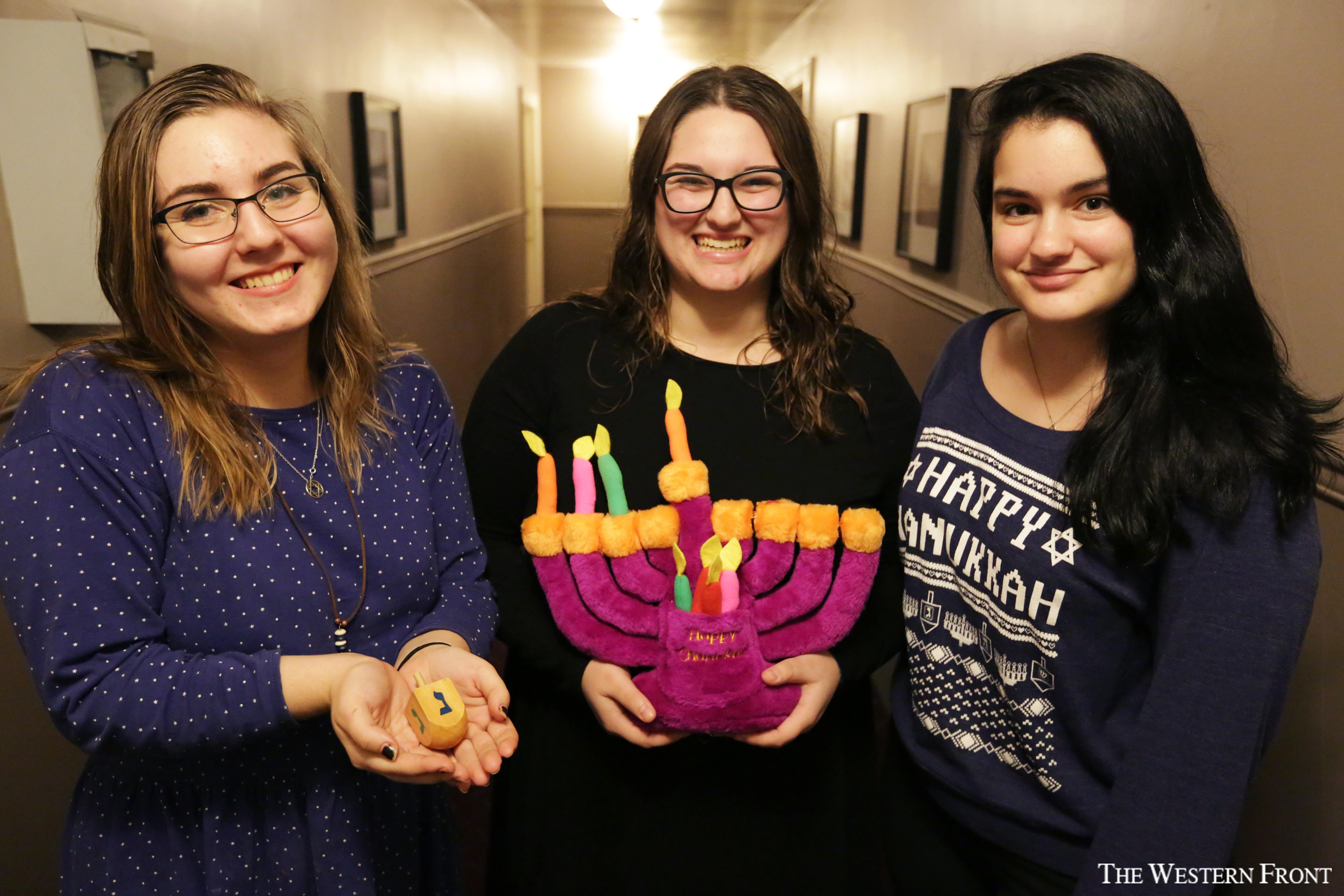 Hillel members Emma Mittendorf , Molly Schwartz and Rachel Benezra-Devine gather together around a plush menorah at the club's Chanukah Party on Dec. 4, 2017. 