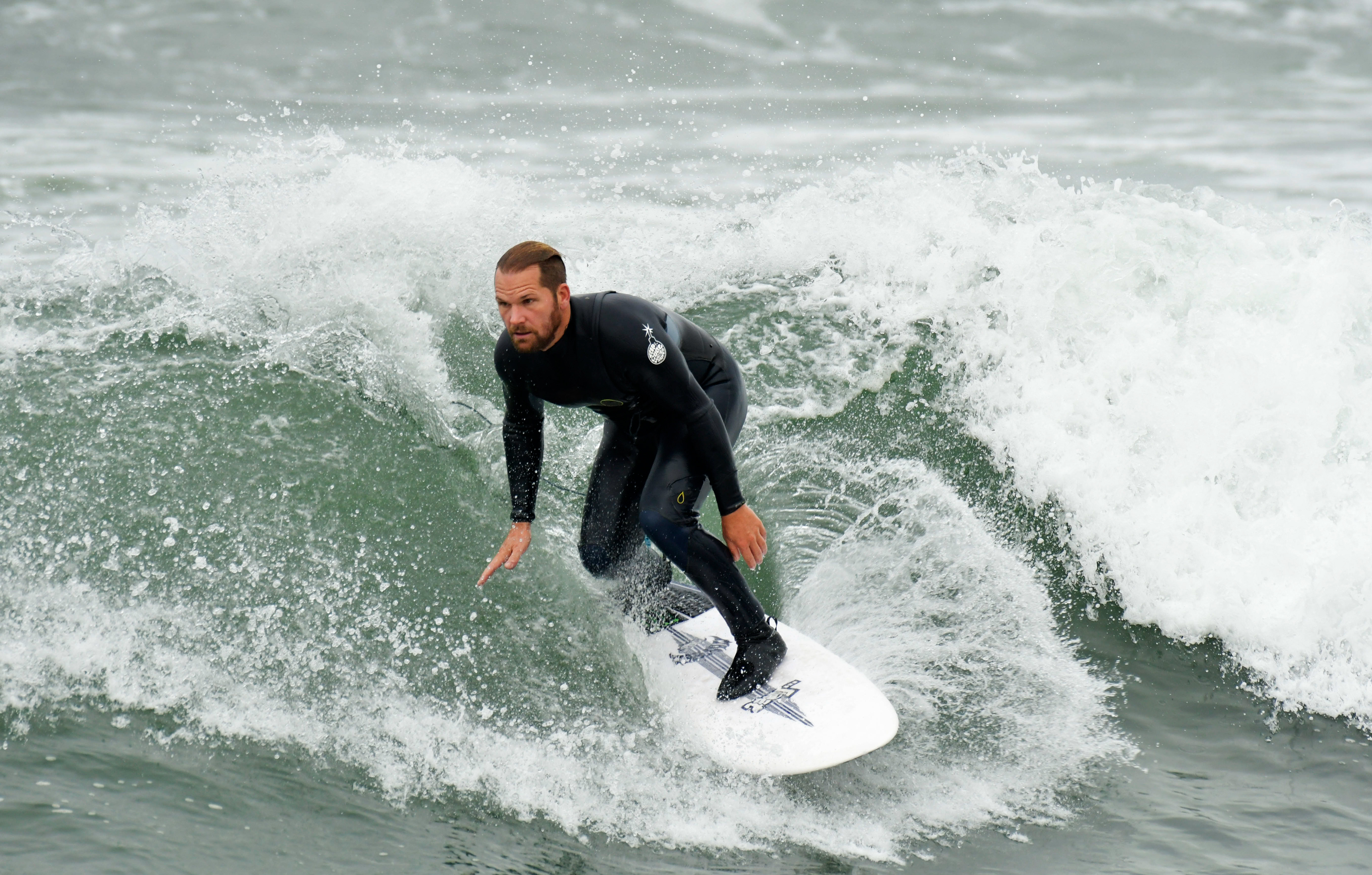 A surfer rides a wave at Huntington Beach, Calif. on Apr. 26, 2018.  