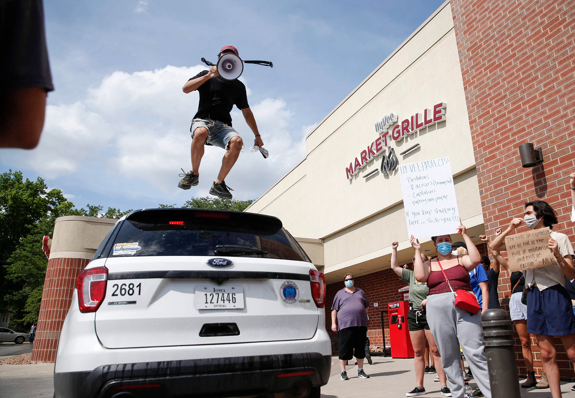 A protester jumps on the roof of a Des Moines police vehicle during a protest in Des Moines on Saturday, June 20, 2020.