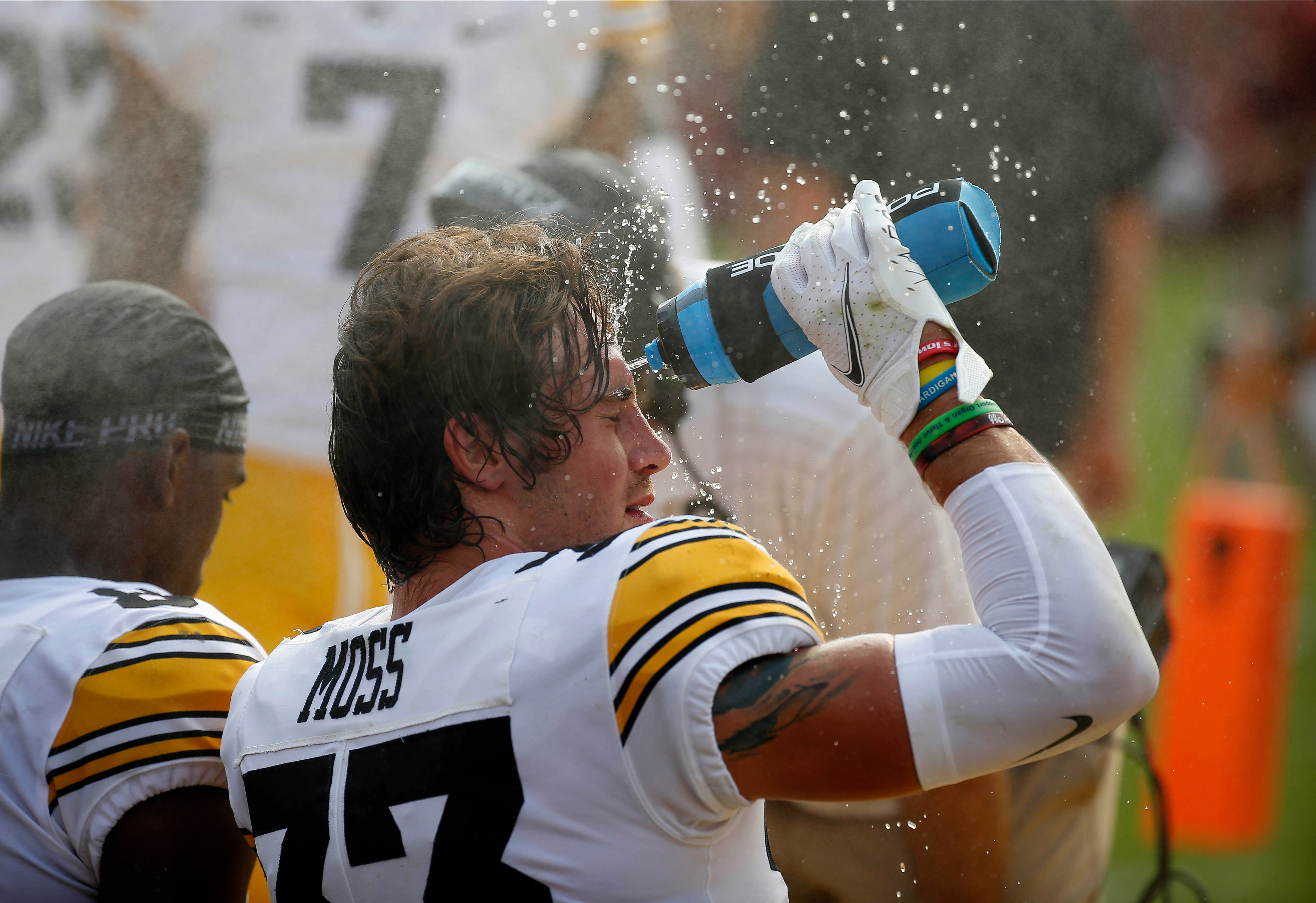 Iowa senior defensive back Riley Moss splashes water on his face to help cool off between the first and second quarter against Iowa State at Jack Trice Stadium in Ames on Saturday, Sept. 11, 2021.