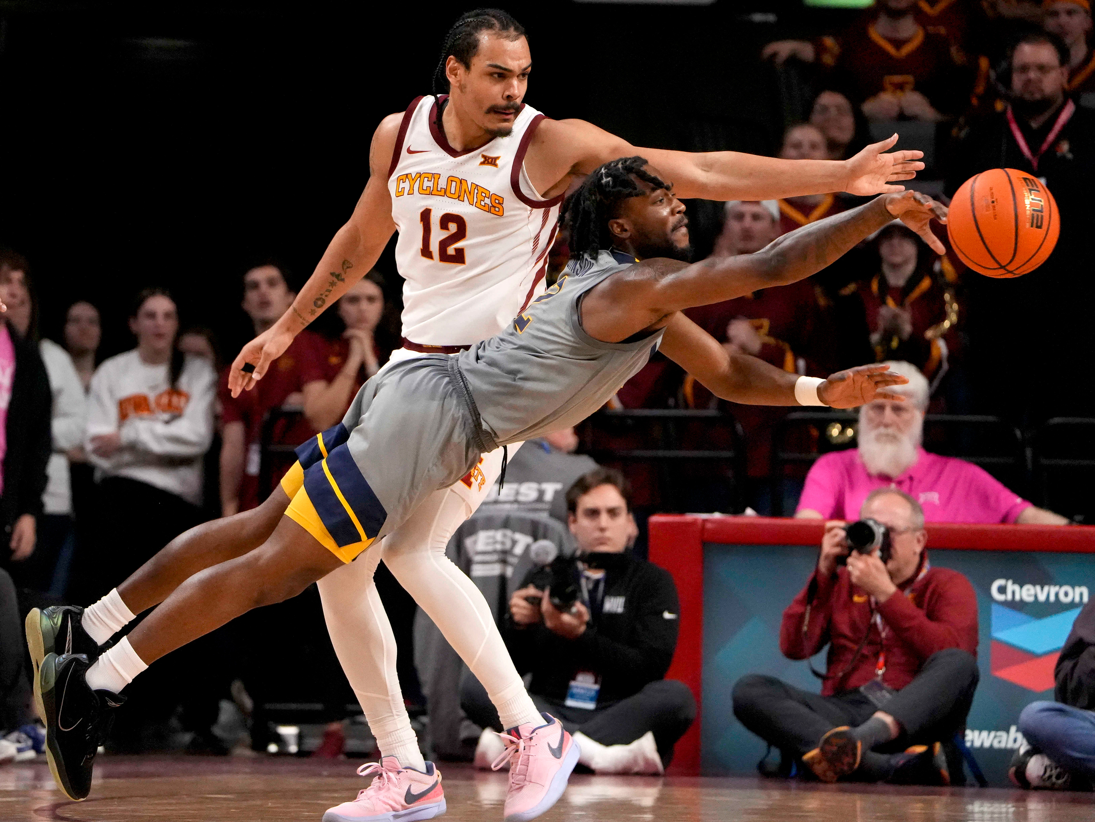 Iowa State forward Robert Jones (12, left) knocks the ball away from West Virginia guard Kobe Johnson (2) in the second half during an NCAA college basketball game, Saturday, Feb. 24, 2024, in Ames, Iowa. (AP Photo/Bryon Houlgrave)