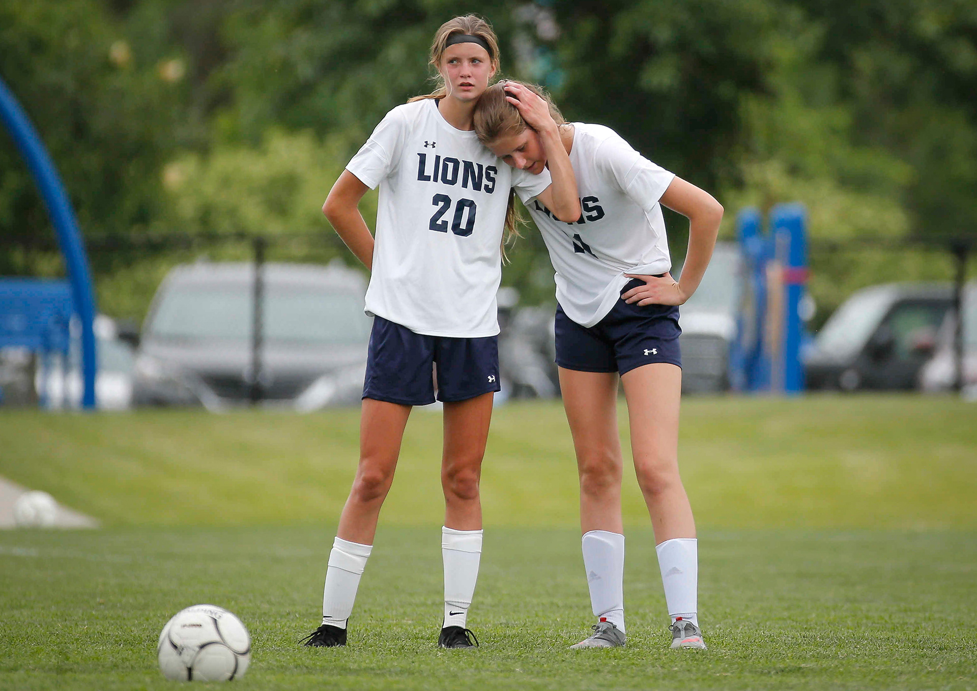 Des Moines Christian freshman Gianna Bennett, left, comforts sophomore Kaitlyn Mumm in the last minute of the game against Davenport Assumption during the Class 1A girls state soccer finals match on Friday, June 11, 2021, at Cownie Field in Des Moines. Assumption won, 2-0.