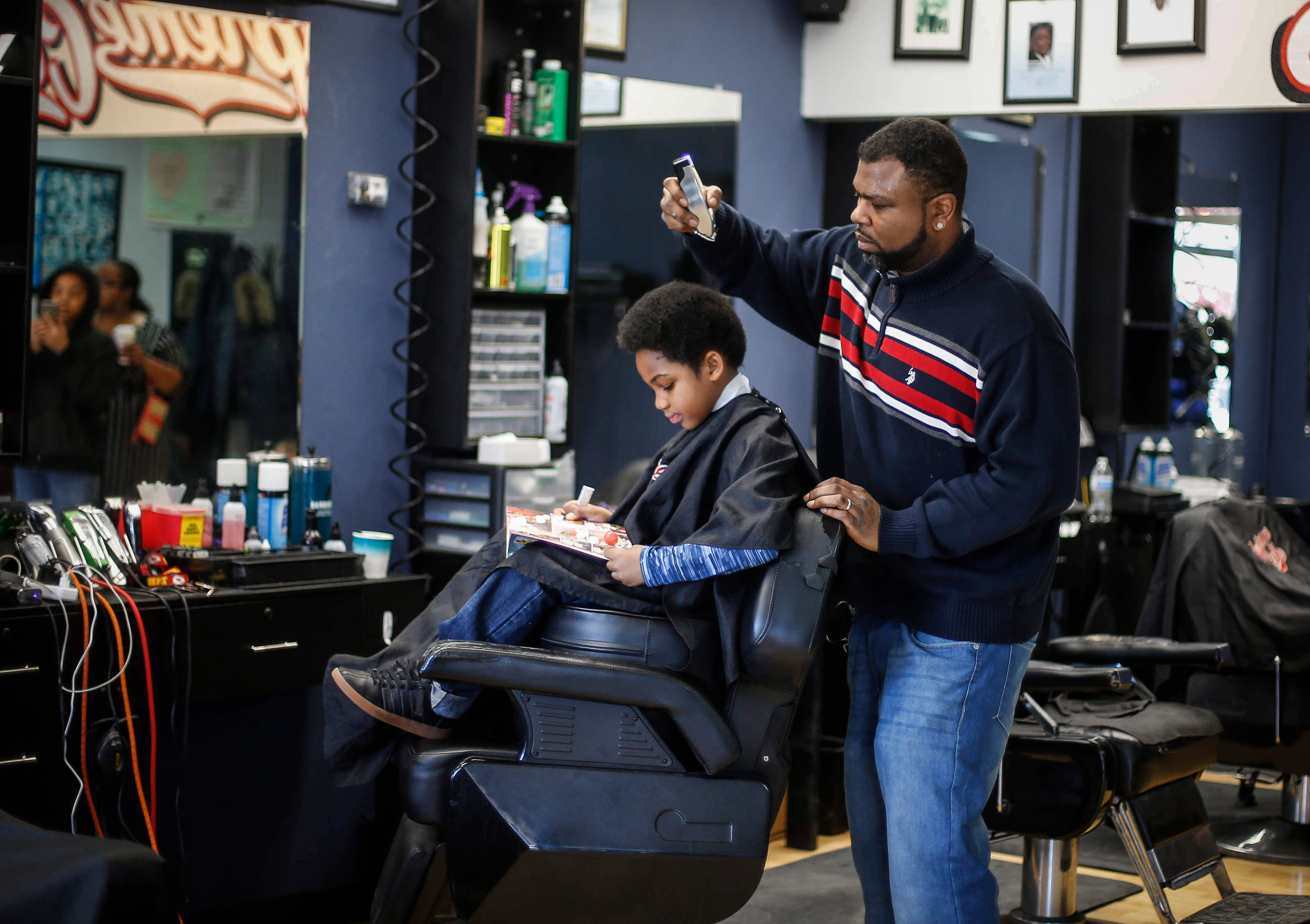 Barber Lance Williams Sr, cuts the hair of Amaru Johnson, 7, of Des Moines, as Johnson reads a book during Storybook Sundays at Supreme Cuts in Des Moines on Sunday, Feb. 16, 2020. Williams began Storybook Sundays as a way to help the Des Moines community improve literacy. 