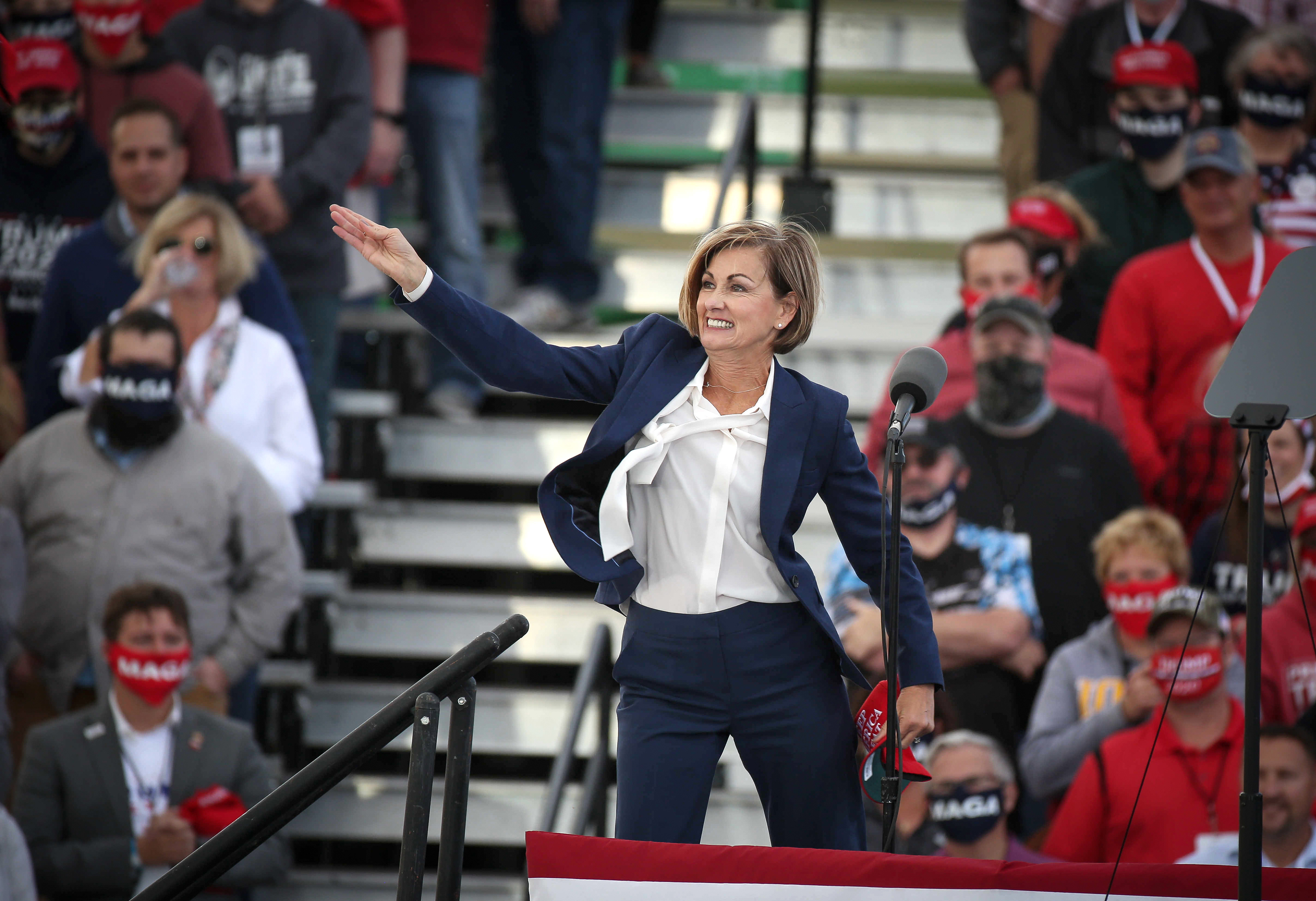 Iowa Gov. Kim Reynolds tosses Keep America Great hats prior to the arrival of U.S. President Donald Trump at the Des Moines International Airport during a rally in Iowa on Wednesday, Oct. 14, 2020.
