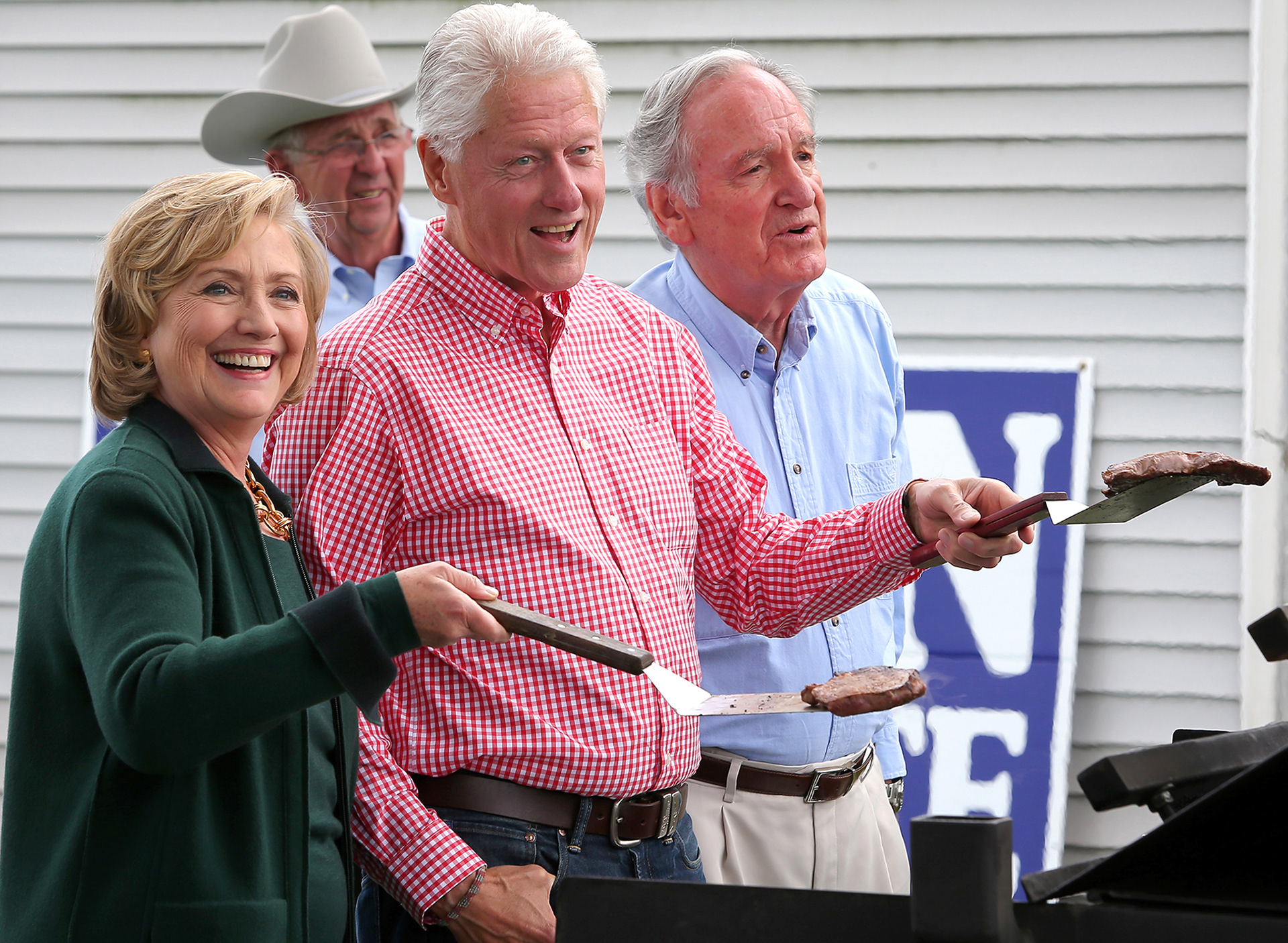 Former President Bill Clinton, joined by his wife and current democratic presidential candidate Hillary Clinton, and Iowa Sen. Tom Harkin, flip steaks during the final Harkin Steak Fry in Indianola.
