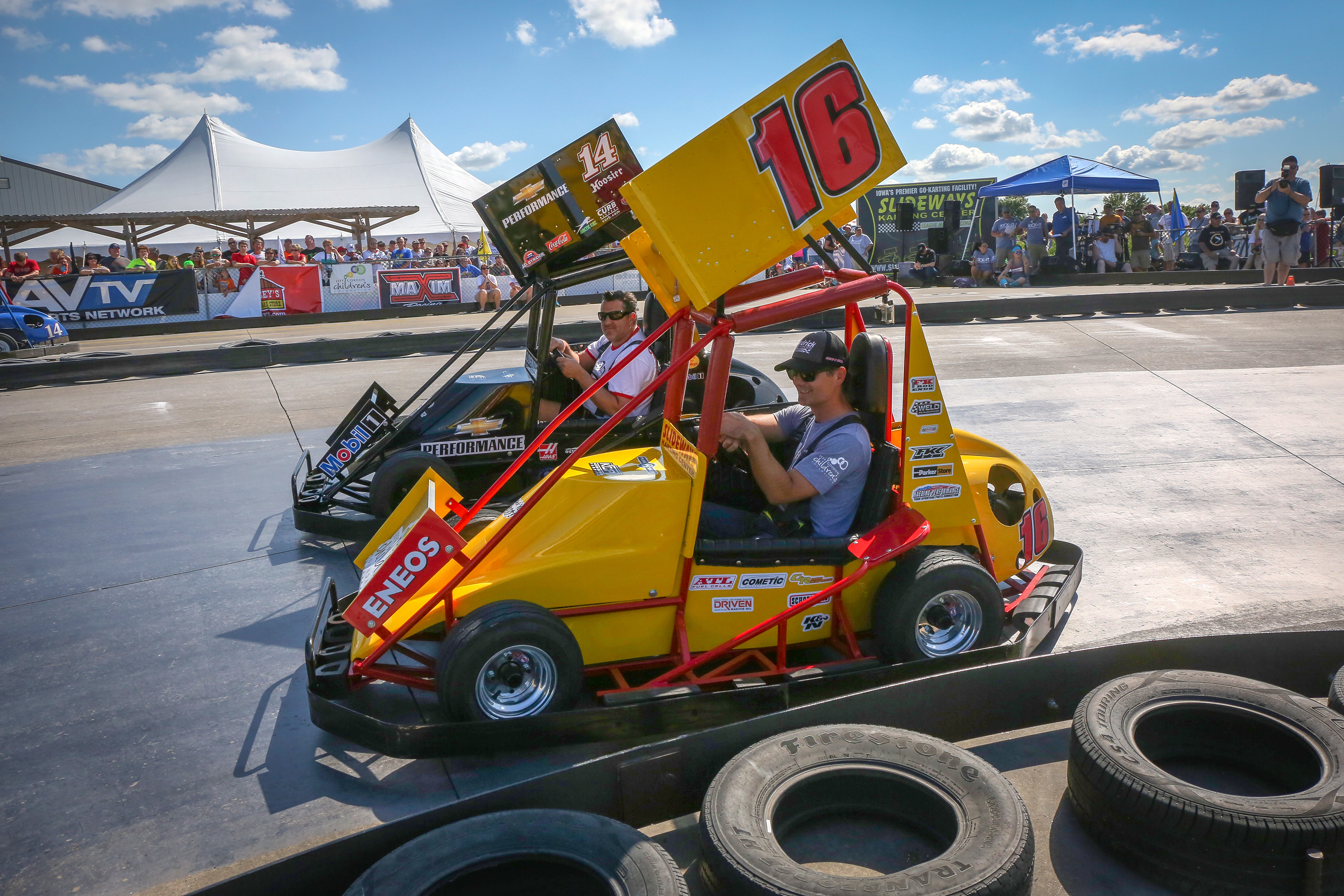 Professional race car drivers Jeff Gordon (16) and Tony Stewart (14) race go-carts around the track at Slideways Karting Center in Knoxville, Iowa, on Aug. 12, 2014.