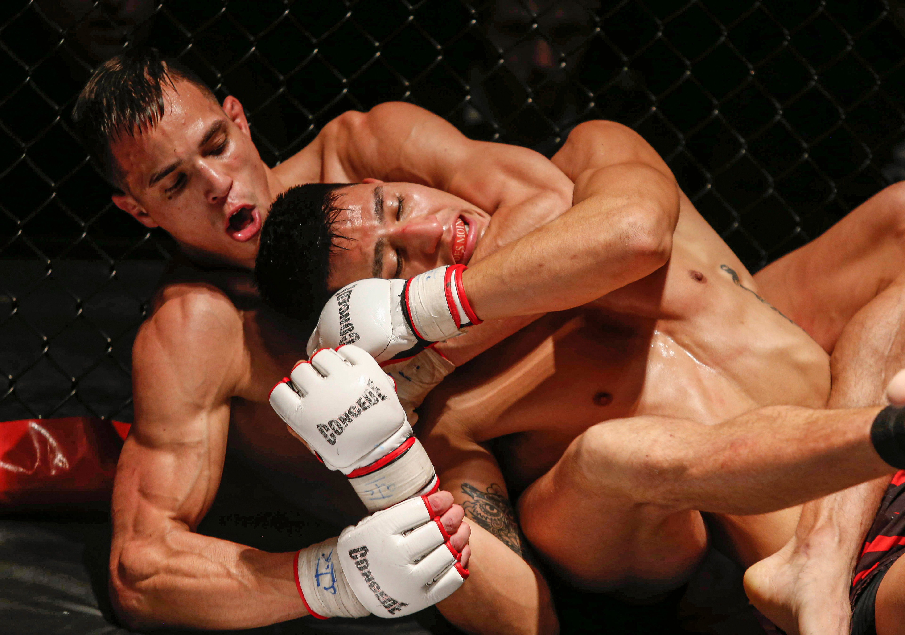 Anthony Baccam, a MMA fighter from Des Moines, left, works to get in tight to choke opponent Luis Saldana of Des Moines in their featherweight fight during the Midwest Cage Championships Thanksgiving Throwdown on Wednesday, Nov. 25, 2015, in Des Moines.
