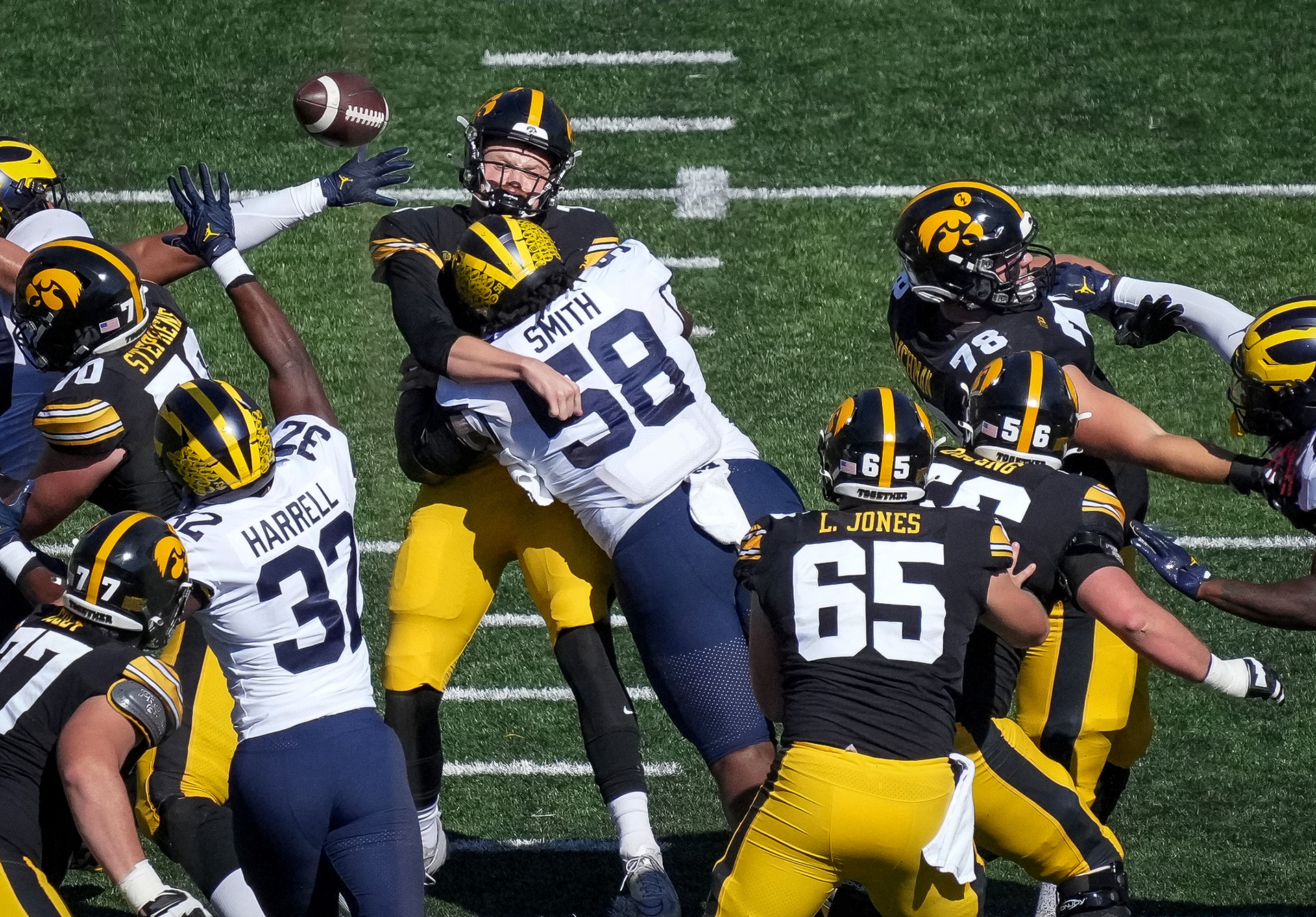 Iowa quarterback Spencer Petras is hit as he throws by Michigan defensive lineman Mazi Smith (58) during a NCAA college football game at Kinnick Stadium in Iowa City on Saturday, Oct. 1, 2022.