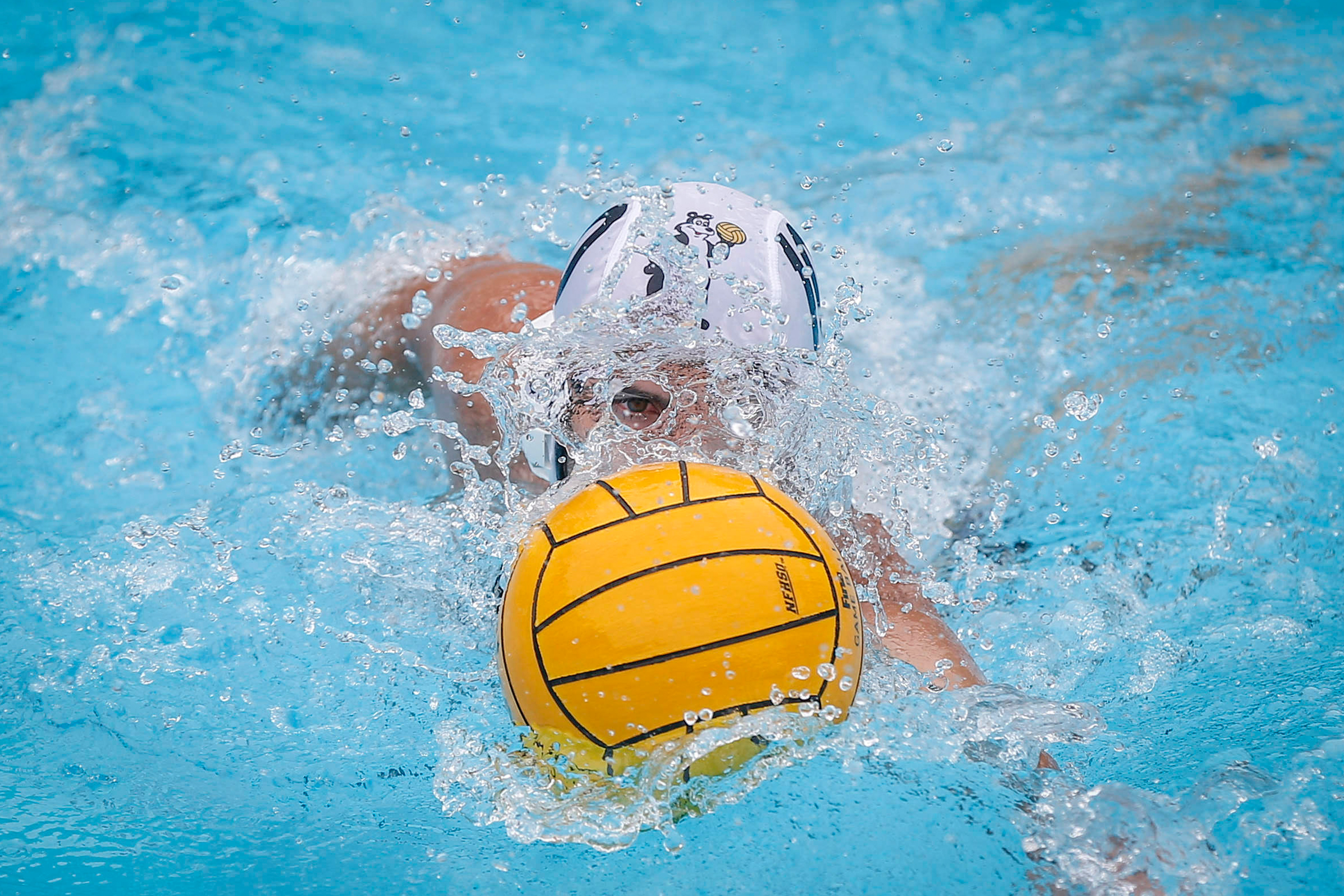 Water frames the eye of Kevin Hyler of the Des Moines Polo Bears as he moves the ball towards the net in the second half against Madison on Saturday, July 13, 2019, at Ashworth Pool in Des Moines during the Des Moines Water Polo Tournament hosted by the Des Moines Water Polo Club.