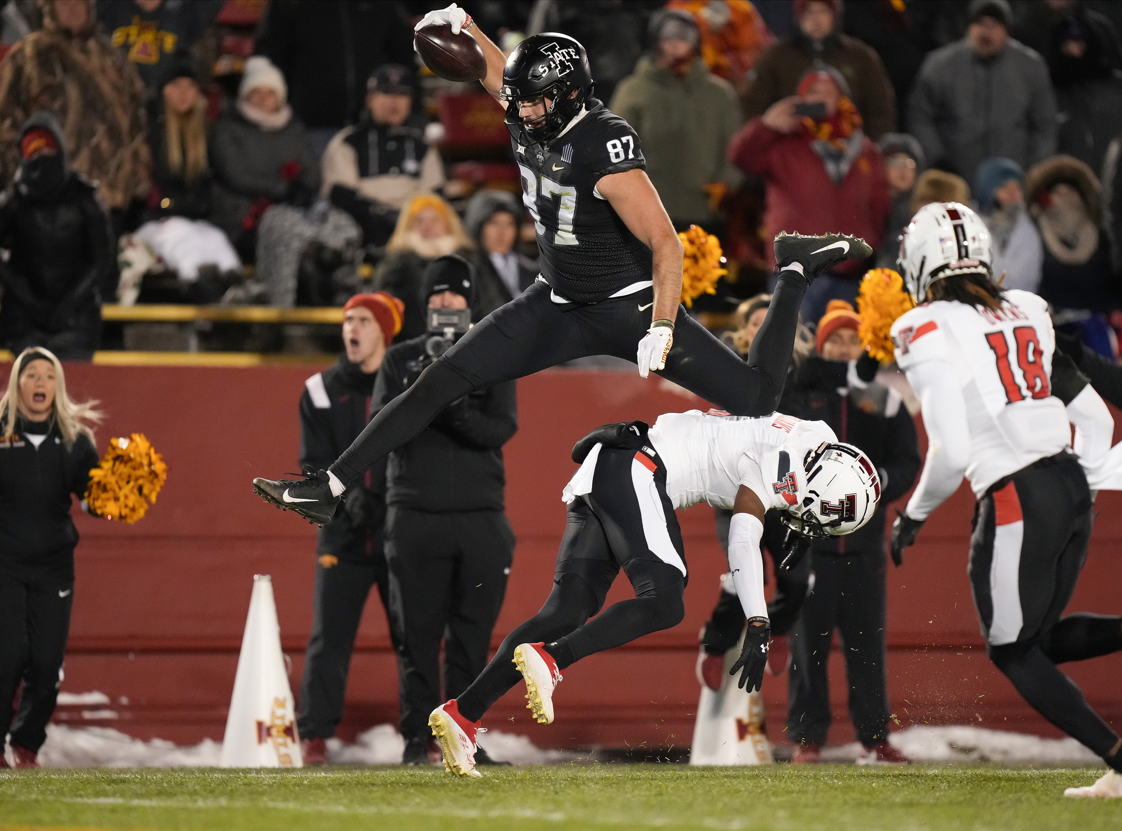 Iowa State tight end Easton Dean hurdles Texas Tech defensive back Rayshad Williams en route to the end zone for a touchdown during a NCAA football game on Saturday, Nov. 19, 2022, at Jack Trice Stadium in Ames.