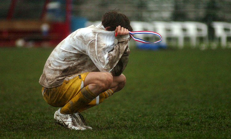 Catholic Memorial's Jordan Beres buries his head in his jersey after collecting his state runner-up soccer medal.