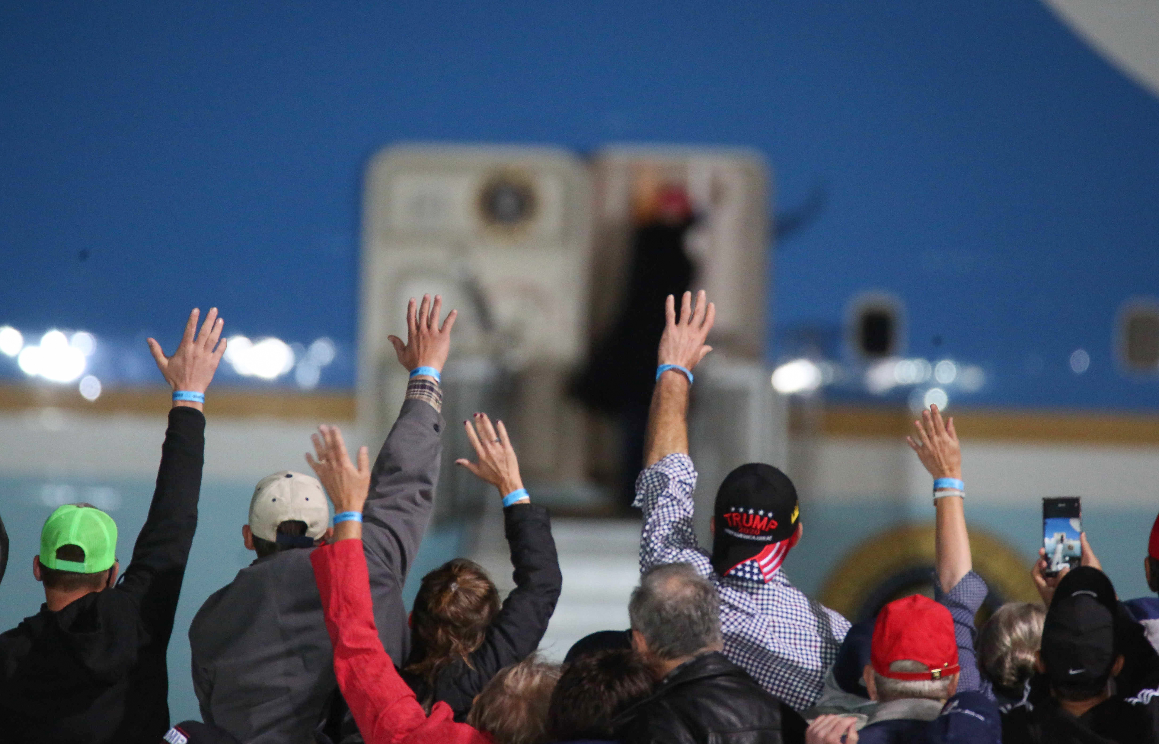 U.S. President Donald Trump trades good-bye waves with supporters as he boards Air Force One after speaking in Des Moines, Iowa, on Wednesday, Oct. 14, 2020.