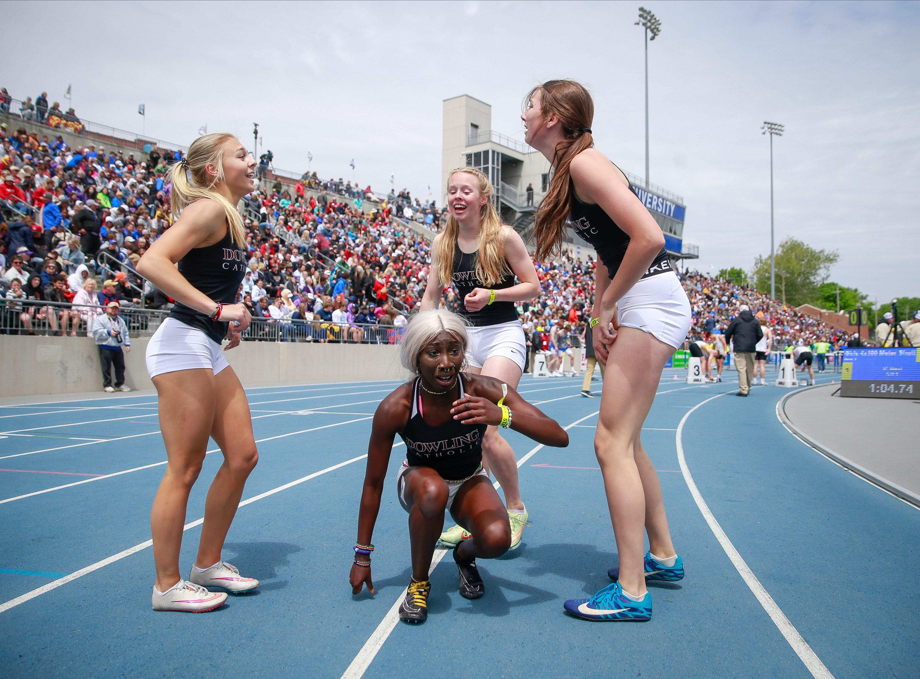 Members of the Dowling Catholic shuttle hurdle relay team celebrate after winning a Class 4A state title during the Iowa high school state track and field meet at Drake Stadium in Des Moines on Saturday, May 21, 2022.
