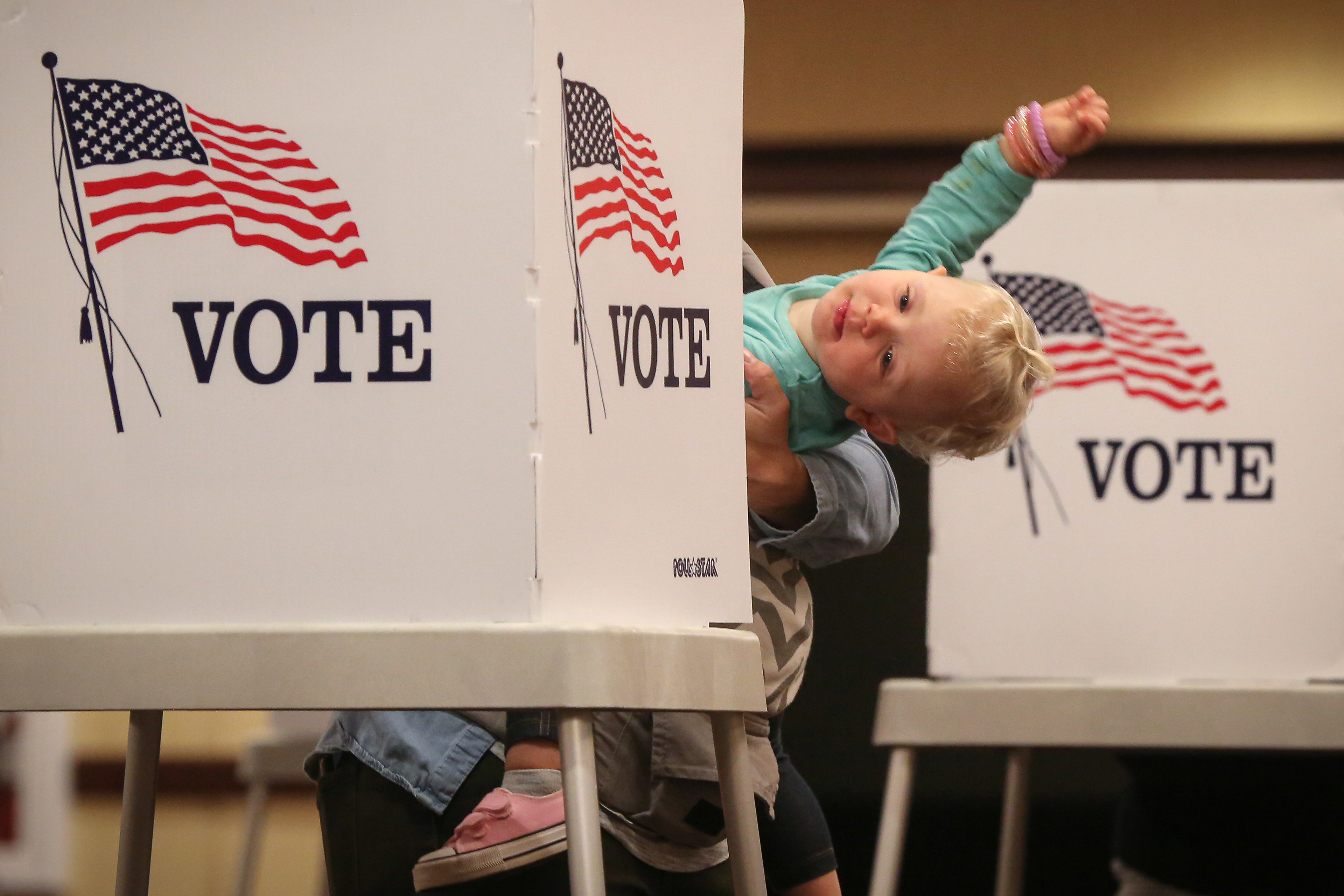 Bre Maxwell of West Des Moines balances her 22-month-old daughter, Emerson, on her hip as she fills out her ballot on Election Day in West Des Moines, Iowa, on Tuesday, Nov. 3, 2020.
