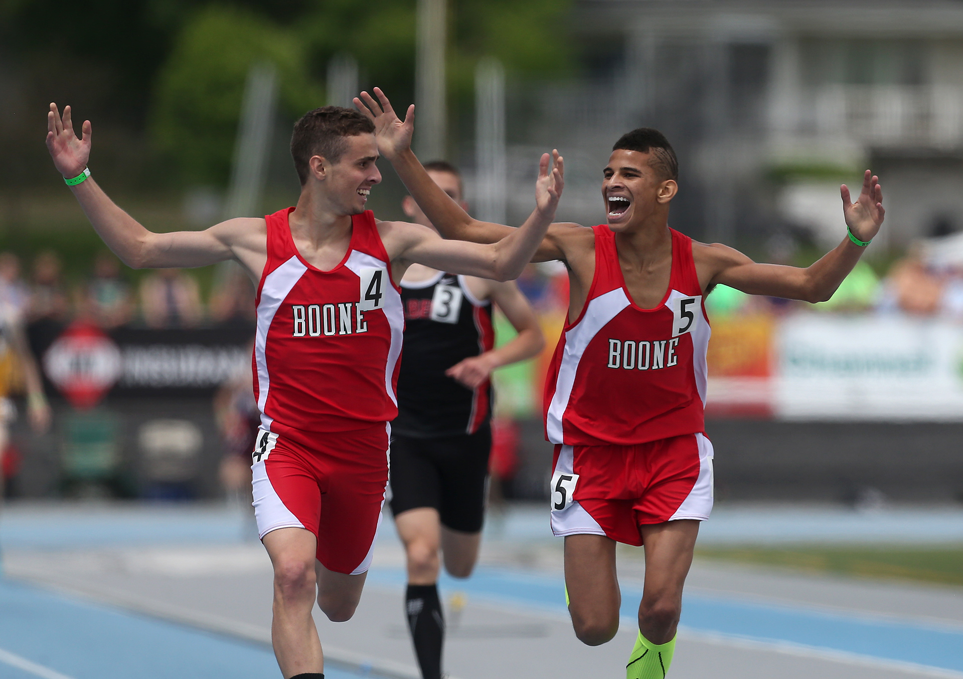 Boone seniors Chandler Austin, left, and Albert Meier, right, celebrate as they head to the finish line in the 1600-meter run in Iowa Class 3A on Saturday, May 24, 2014, during the Iowa state high school track and field meet at Drake Stadium in Des Moines. Austin won the event.