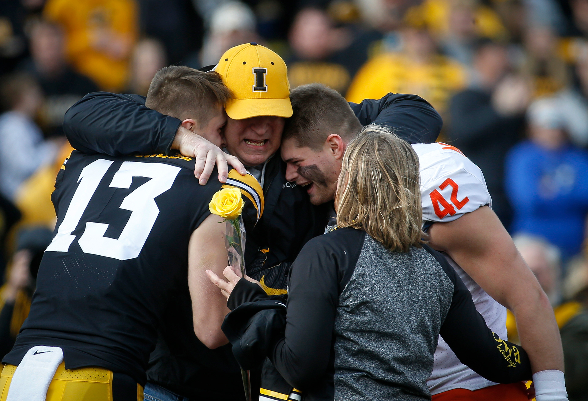 Former Iowa Hawkeye running back John Marchese hugs his sons, Iowa senior defensive back Henry Marchese, left,  and brother Michael, a tight end for the University of Illinois, during a senior day ceremony prior to kickoff against Illinois on Saturday, Nov. 20, 2021, at Kinnick Stadium in Iowa City, Iowa.