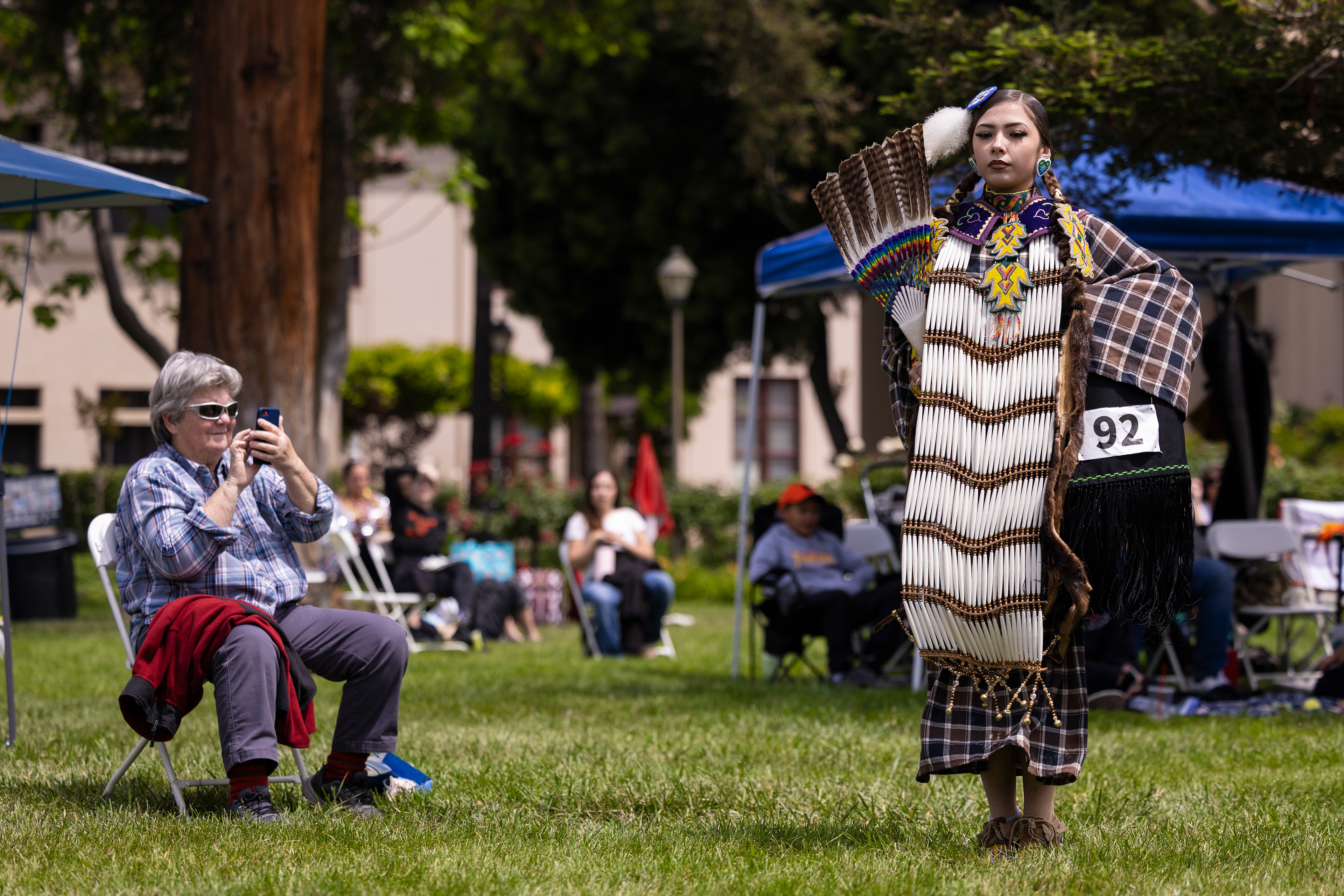An audience member films Autumn Rain Hackett dancing at Santa Clara University’s sixth annual powwow on Saturday, May 2, 2026, on St. Ignatius Lawn. (Nina Glick/The Santa Clara)