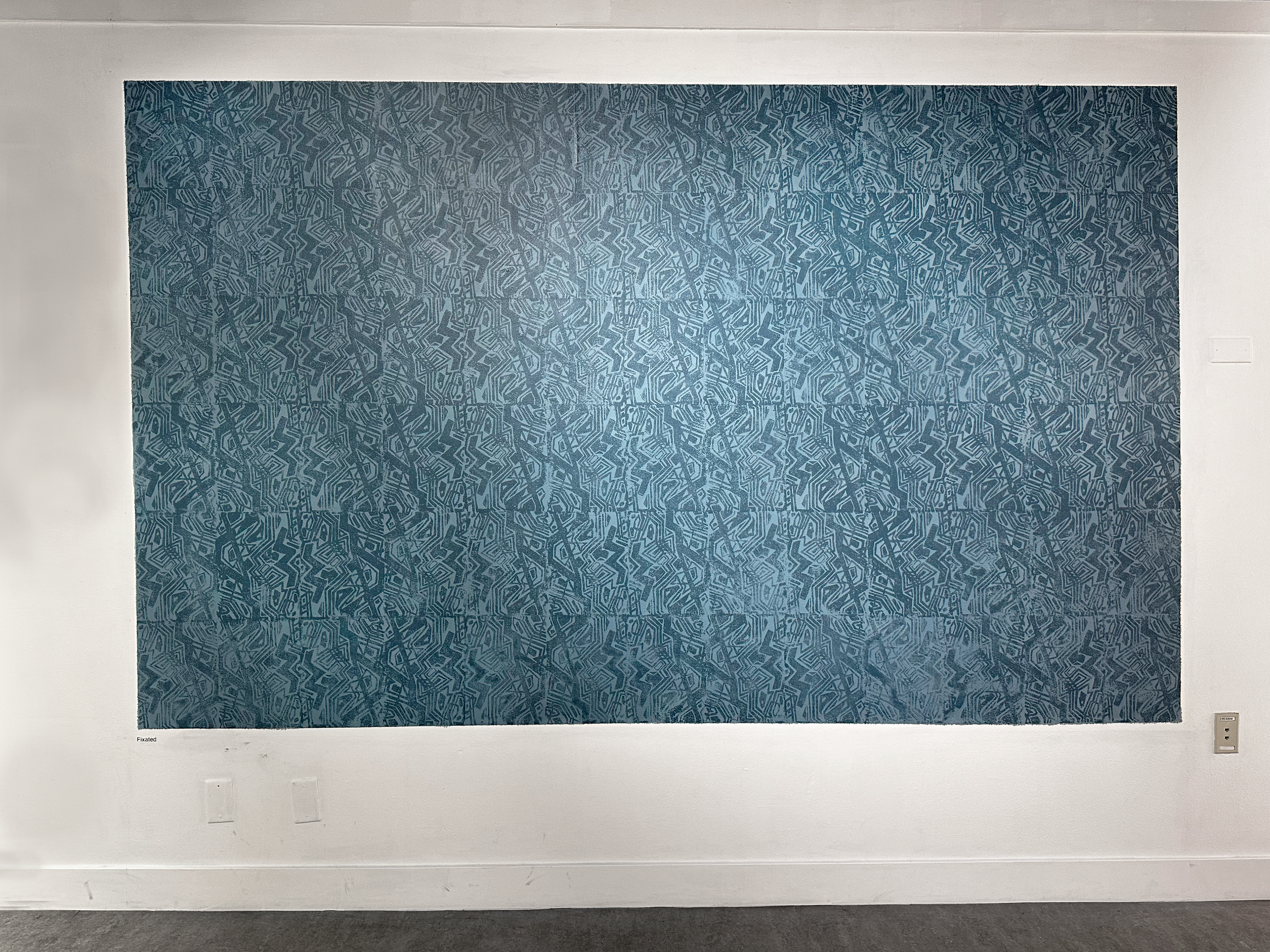"Fixated," 2023, acrylic linoleum block prints on wall, 6x10 feet