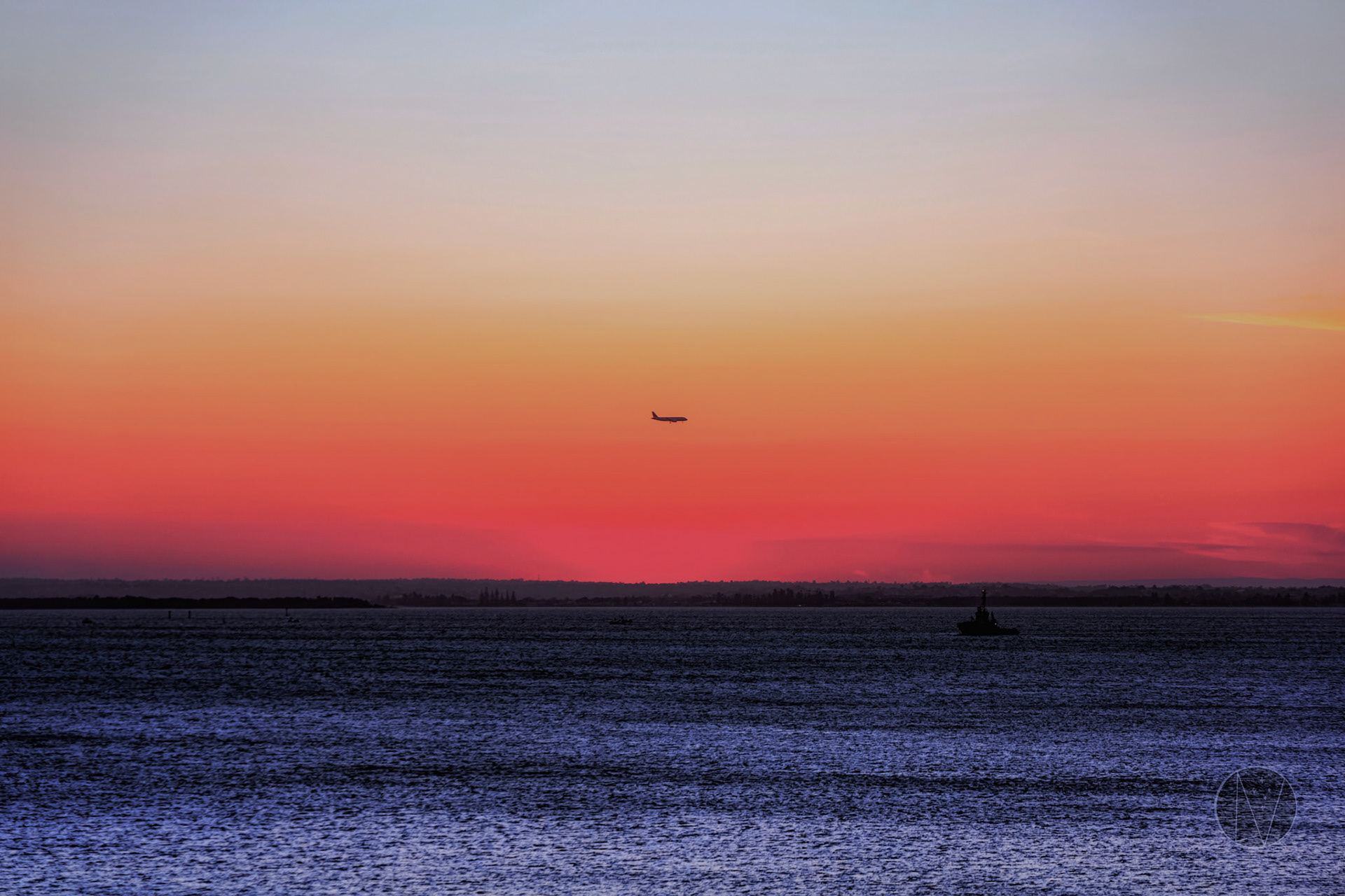 A plane flying in front of a sunset